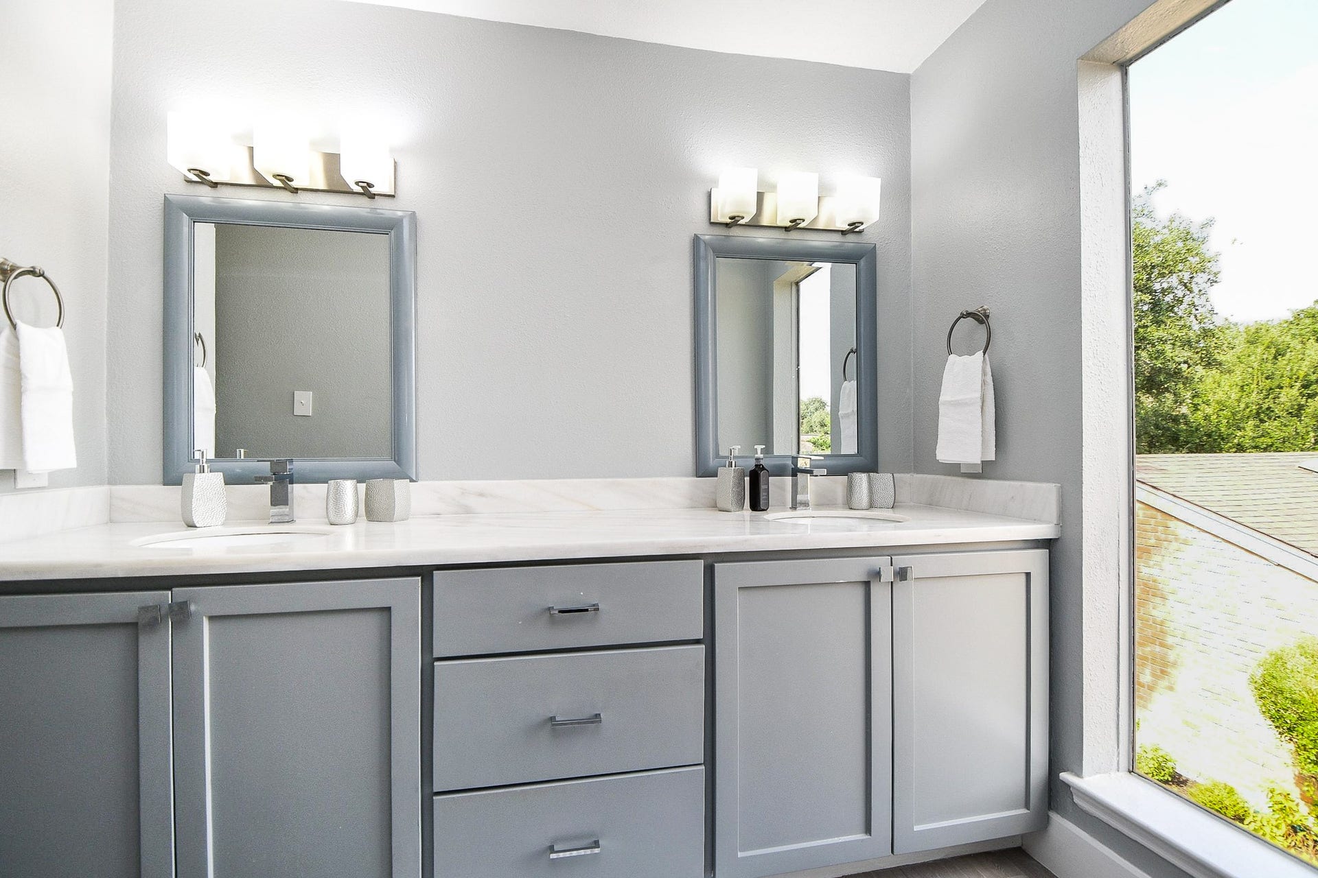 811 Bayou River Drive, Houston, TX 77079 The primary bath has double sinks, framed mirrors, and modern lighting.