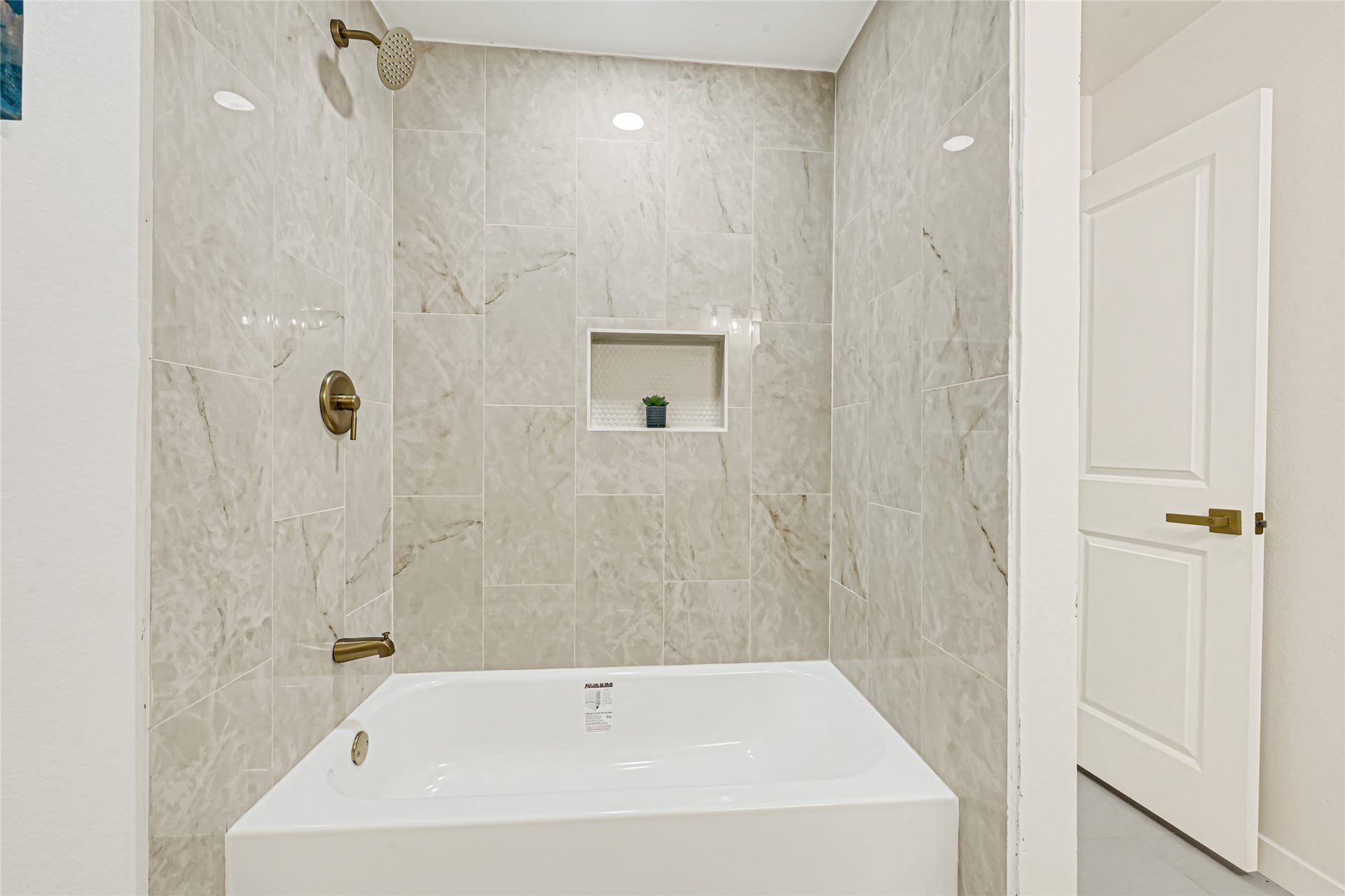 11102 Sagecanyon Drive, Houston, TX 77089 Updated guest bathroom featuring a beautifully tiled tub and shower with elegant brushed gold fixtures.