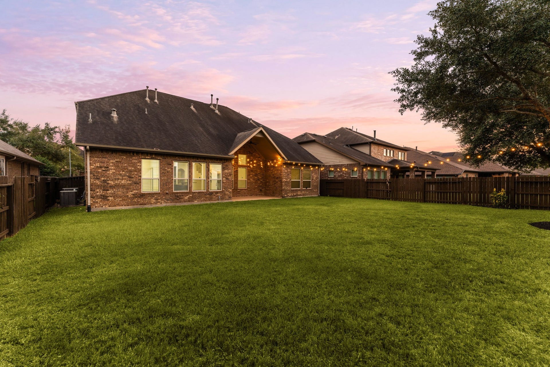 9931 Hutton Park Drive, Katy, TX 77494 This beautifully maintained rear lawn showcases the impressive scale of the homes all-brick exterior against a stunning sunset backdrop. The sprawling green space is fully enclosed by privacy fencing, providing a secure and serene environment with plenty of room to add a custom pool, garden paths, or a dedicated play area.