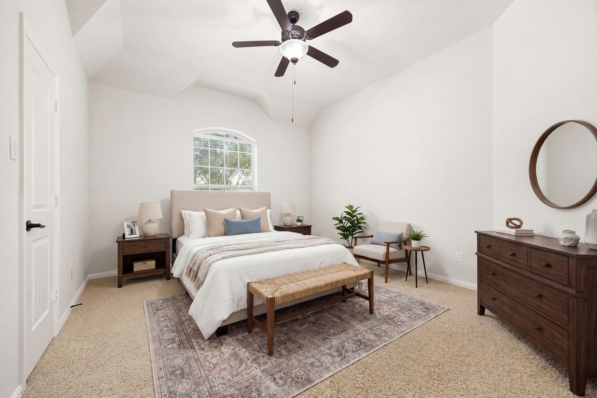 9931 Hutton Park Drive, Katy, TX 77494 This spacious room stands out with its dramatic, high vaulted ceiling accented by a modern central ceiling fan. The bright, neutral palette and soft carpeting create a cozy yet open ambiance, while a well-placed window frames peaceful views of the surrounding property.