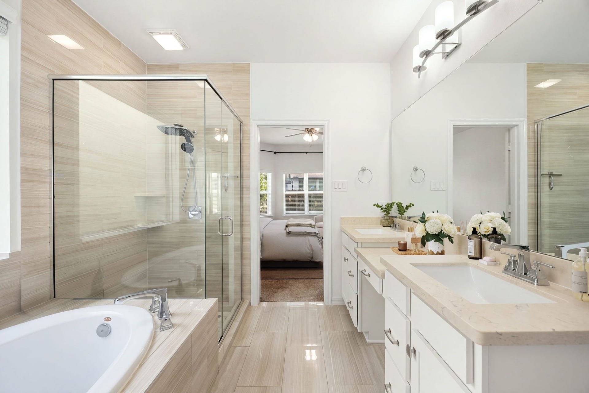 30715 Parkside Passage Drive, Fulshear, TX 77441 The luxurious primary en-suite bathroom replicates a spa-like experience, anchored by an expansive dual-sink vanity with plenty of cabinet storage and a dedicated makeup vanity seating station. Opposite the vanity sits a deep soaking tub alongside a massive, seamless glass-enclosed shower wrapped in elegant linear tiling. *Virtually Staged