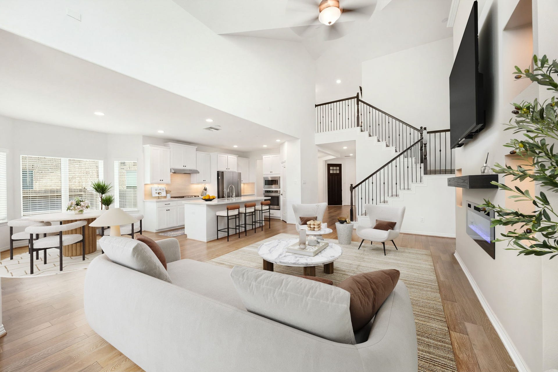 30715 Parkside Passage Drive, Fulshear, TX 77441 An incredible wide-angle view reveals the true scale of this homes open-concept design, where the towering family room integrates flawlessly with the kitchen and casual dining spaces. *Virtually Staged