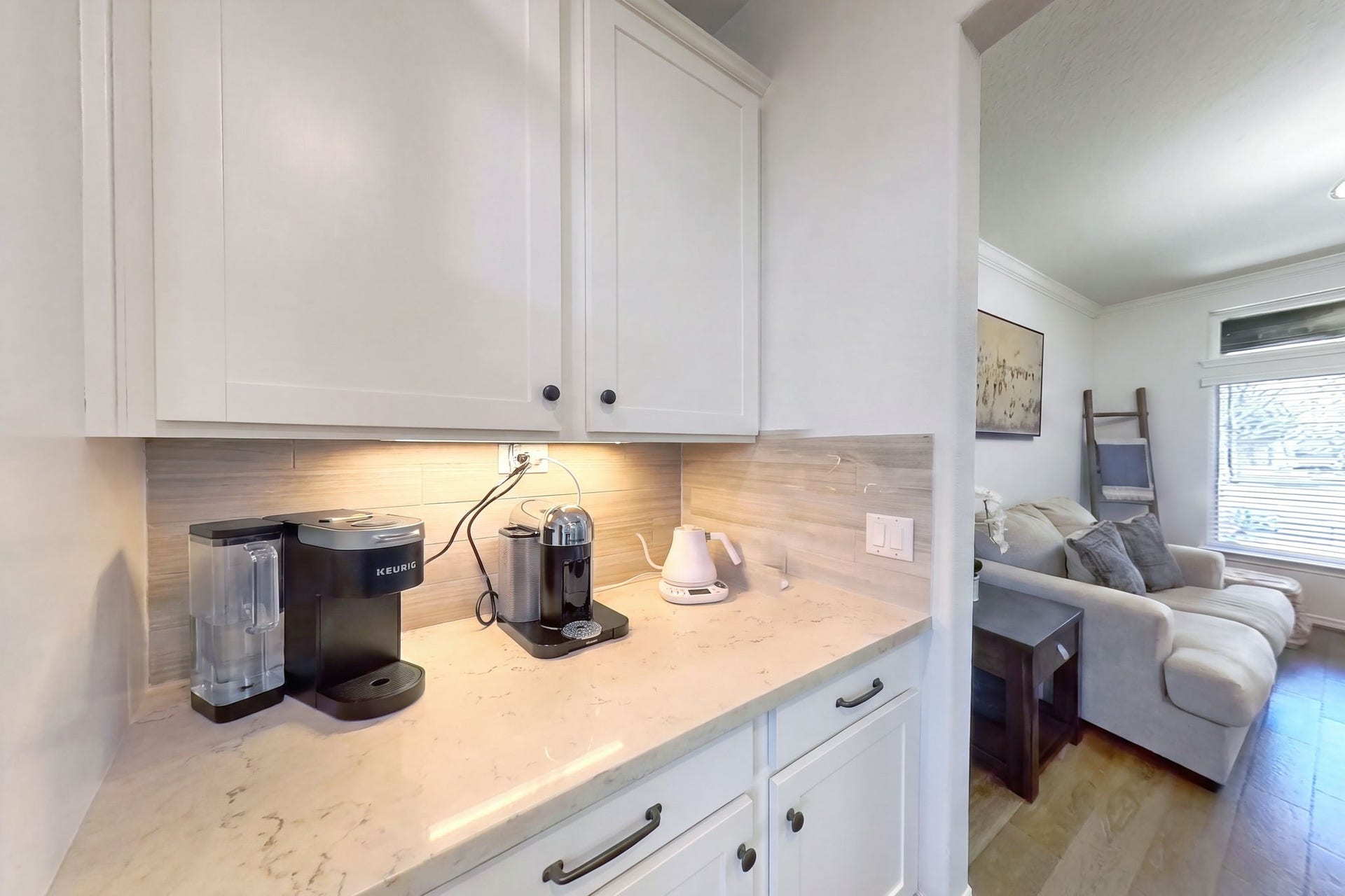 30715 Parkside Passage Drive, Fulshear, TX 77441 Smart space-saving design! Conveniently situated just off the formal dining area, this dedicated butler's pantry provides excellent transitional storage and counter space, featuring elegant white Shaker cabinets and sleek dark hardware.