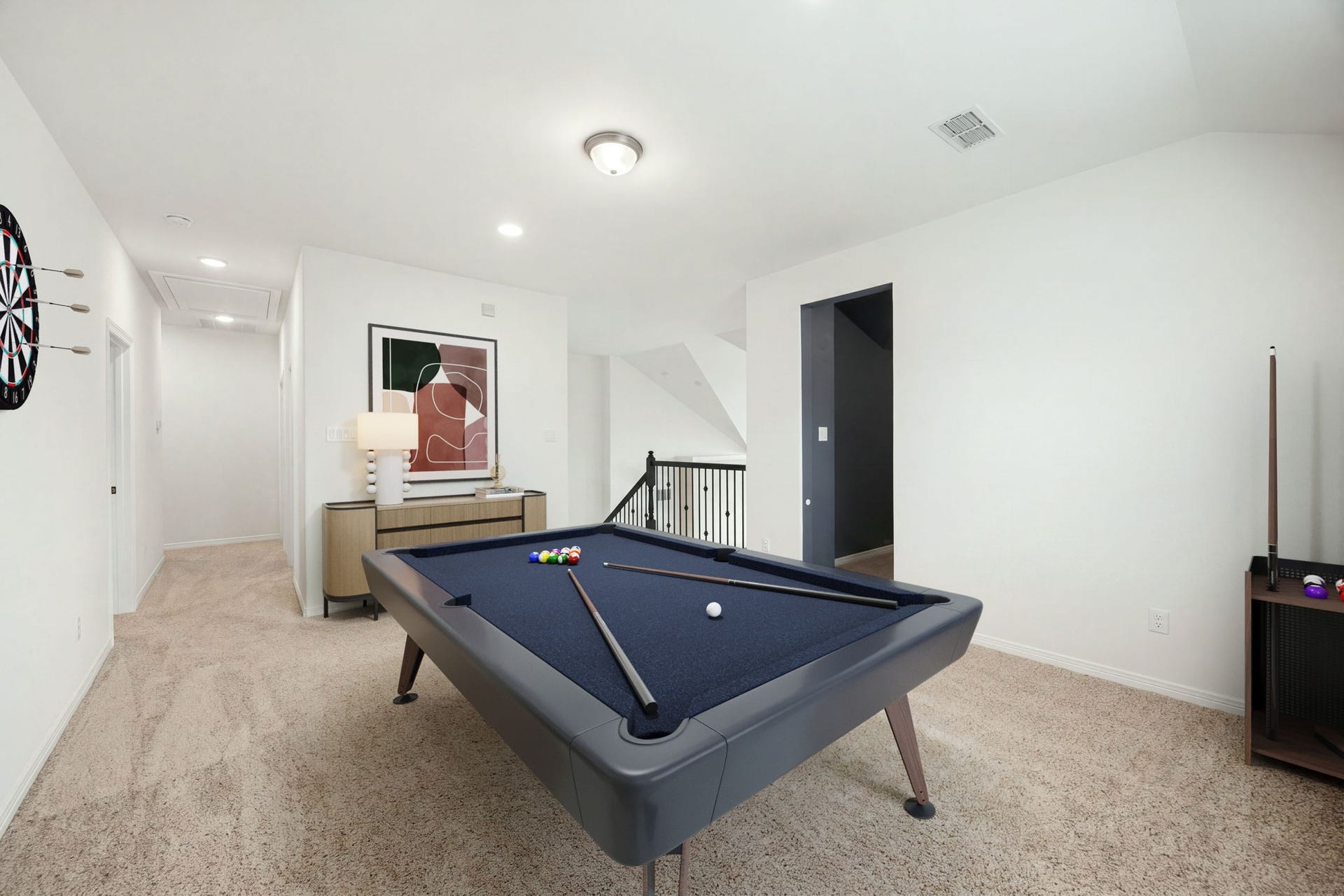 30715 Parkside Passage Drive, Fulshear, TX 77441 This alternate view of the massive upstairs game room highlights its central location and seamless connection to the rest of the second level. The expansive room features plush carpeting and recessed lighting, flowing past a dedicated secondary hallway and opening directly onto the staircase landing with its dark wrought-iron railings. *Virtually Staged