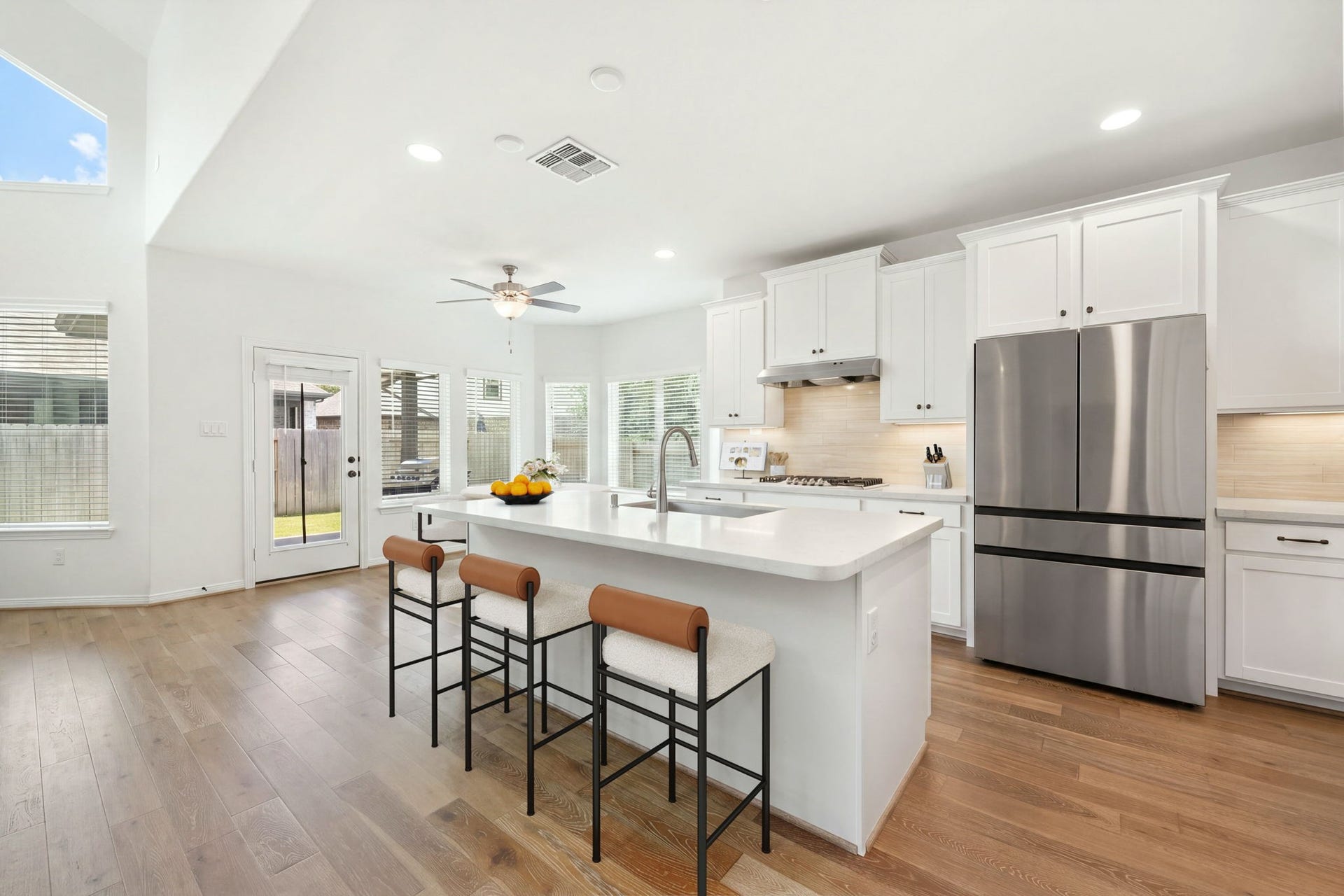 30715 Parkside Passage Drive, Fulshear, TX 77441 This sun-filled gourmet kitchen balances modern functionality with sleek design, anchored by a large central island that features crisp quartz countertops, an undermount sink, a gooseneck faucet, and breakfast bar seating. *Virtually Staged