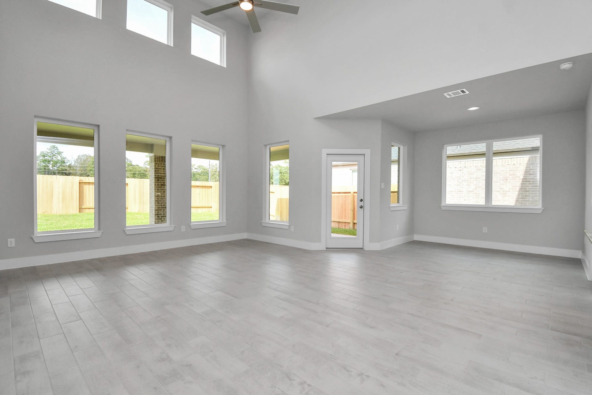 Gather the family and guests together in your lovely living room! Featuring soaring high ceilings, recessed lighting, ceiling fan, custom paint, gorgeous floors, and large windows that provide plenty of natural lighting throughout the day. Sample photo of completed home with similar floor plan. Actual colors and selections may vary.