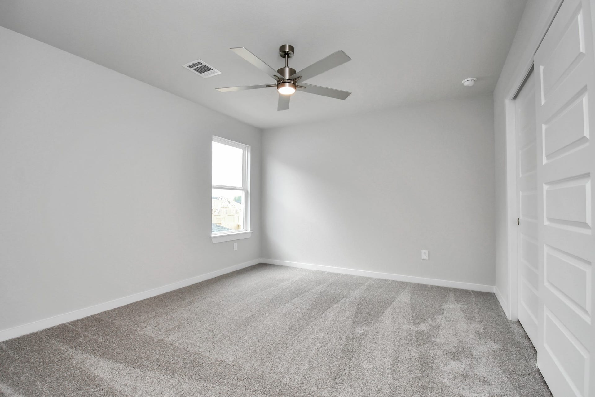 Secondary bedroom features plush carpeting, large windows that let in plenty of natural light, bright paint, and spacious closets. Sample photo of completed home with similar floor plan. Actual colors and selections may vary.