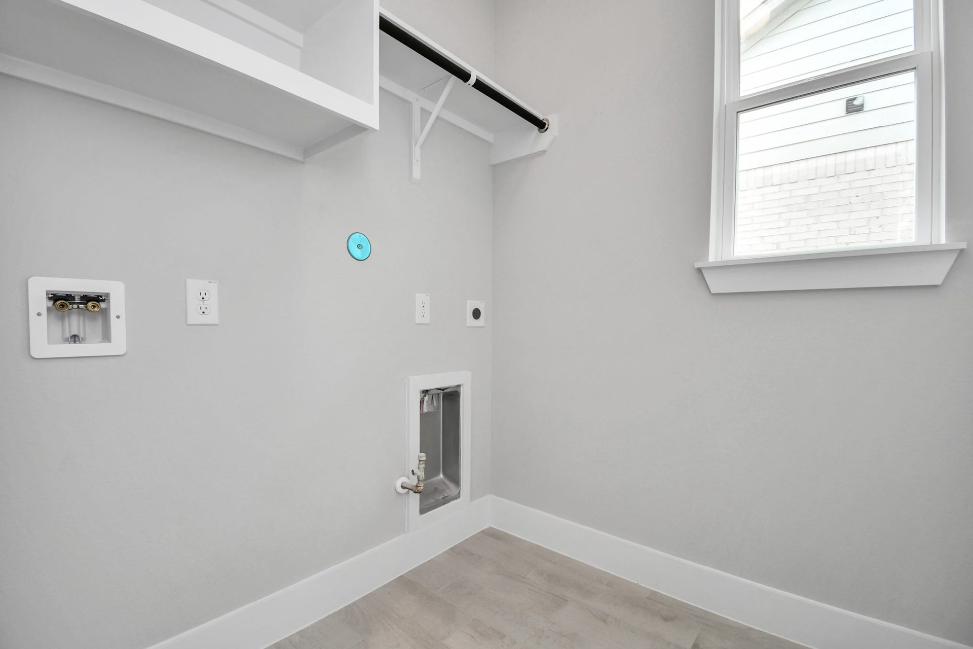 A perfect blend of functionality and comfort. Capture the essence of easy living with a first-floor laundry room, thoughtfully equipped with shelving for effortless organization. Both electric and gas connections available. Sample photo of completed home with similar floor plan. Actual colors and selections may vary.