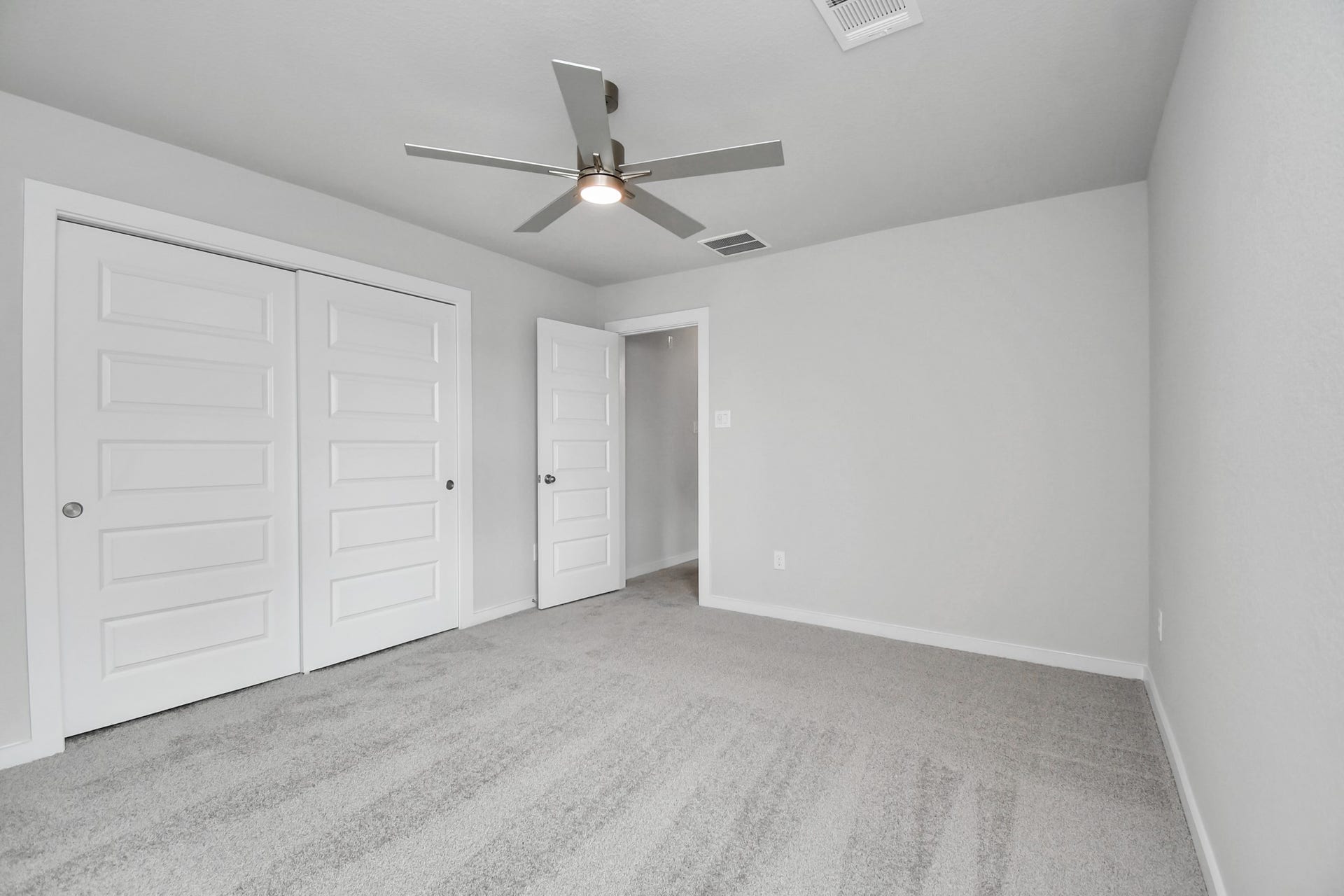 Secondary bedroom features plush carpeting, large windows that let in plenty of natural light, bright paint, and spacious closets. Sample photo of completed home with similar floor plan. Actual colors and selections may vary.