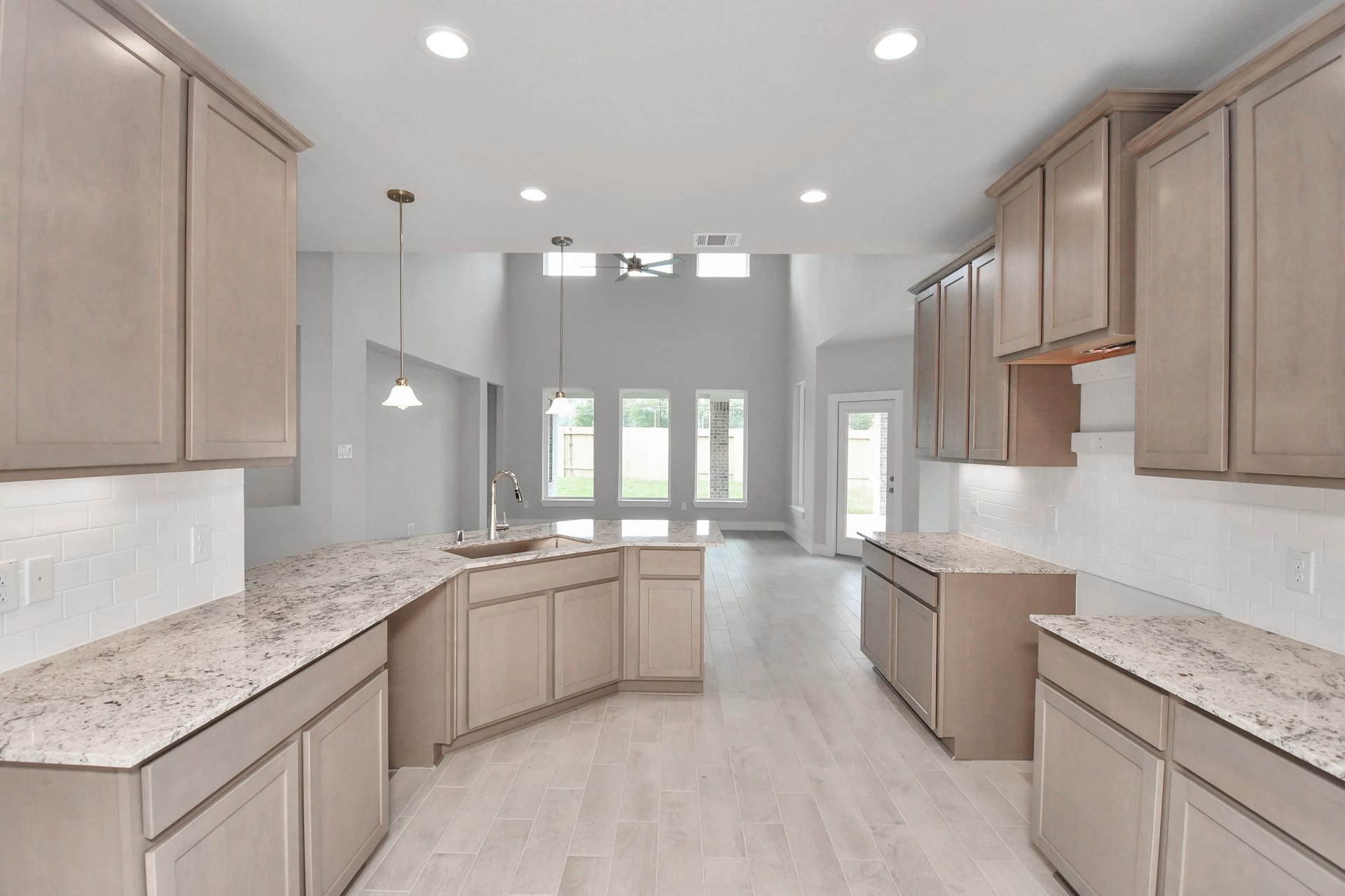 The kitchen is a culinary haven, featuring granite countertops, a tile backsplash, stainless steel appliances, 42 upper cabinets, and undercabinet lighting. Sample photo of completed home with similar floor plan. Actual colors and selections may vary.