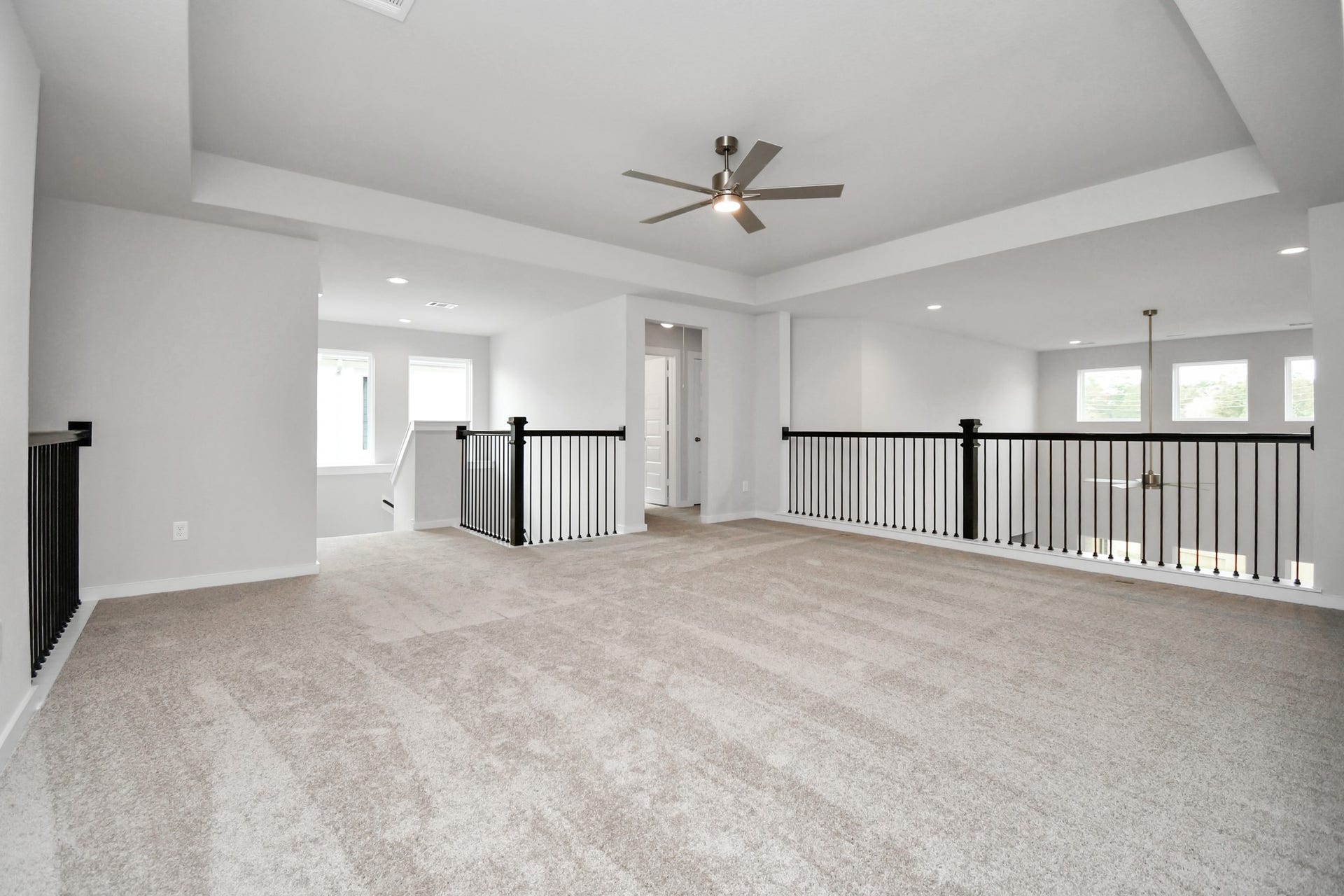 Ascend to relaxation in this fantastic game room! Ideal for both casual gatherings and adult gaming, it boasts plush carpet, lofty ceilings, custom paint, and ample windows for abundant natural light. Sample photo of completed home with similar floor plan. Actual colors and selections may vary.