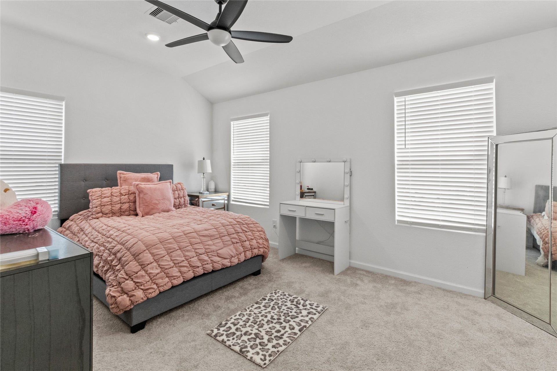 2909 Ballast Green Drive, La Marque, TX 77568 Bright and inviting bedroom with ample natural light from two windows, while the ceiling fan ensures comfort.
