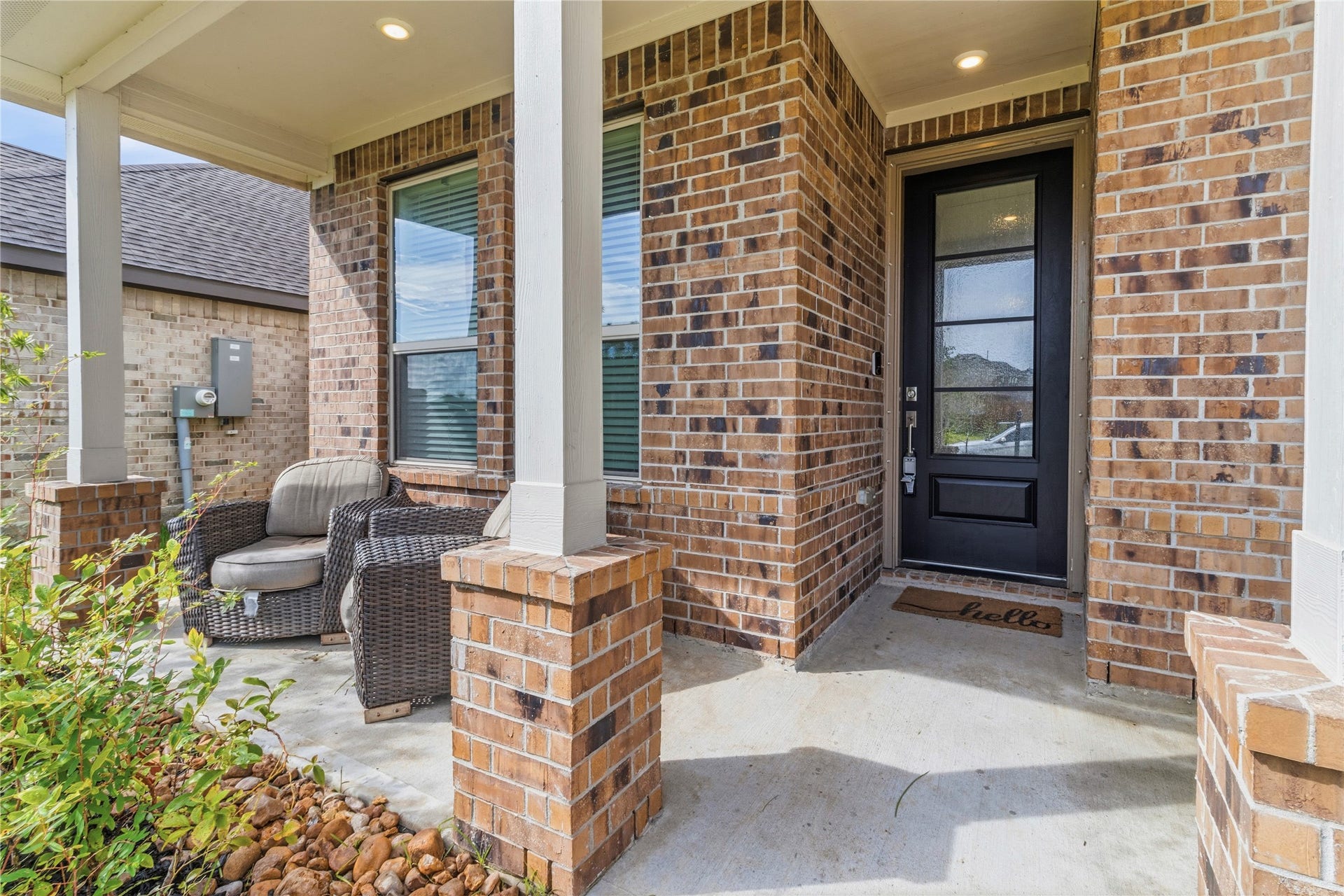 2909 Ballast Green Drive, La Marque, TX 77568 Charming brick front porch with cozy wicker seating and a welcoming entryway, perfect for relaxing and greeting guests.