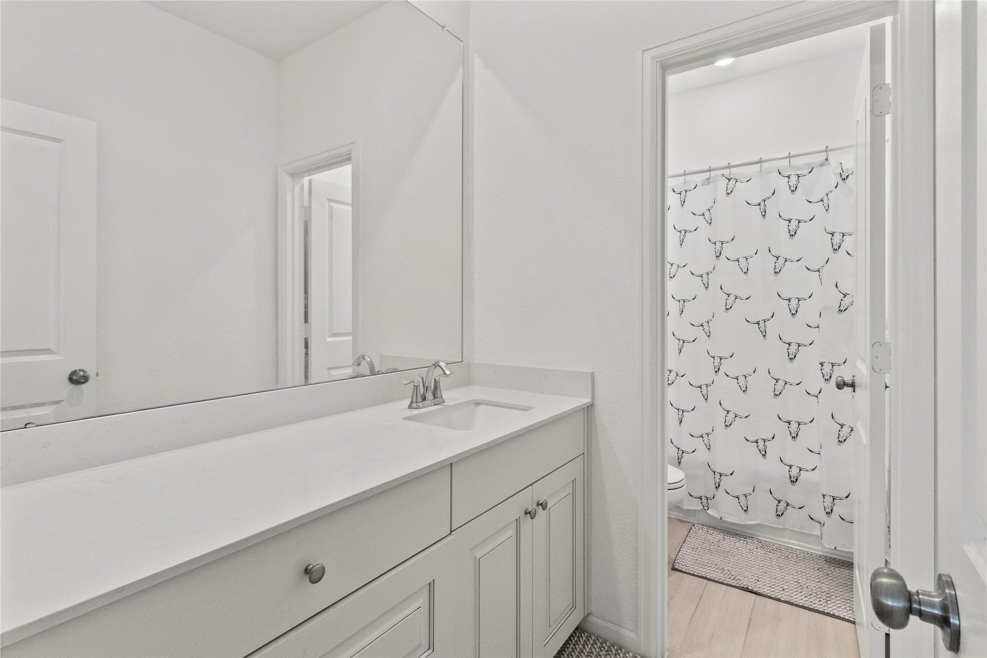 2909 Ballast Green Drive, La Marque, TX 77568 Bright, modern bathroom featuring a sleek vanity with ample counter space and a stylish shower curtain accent.