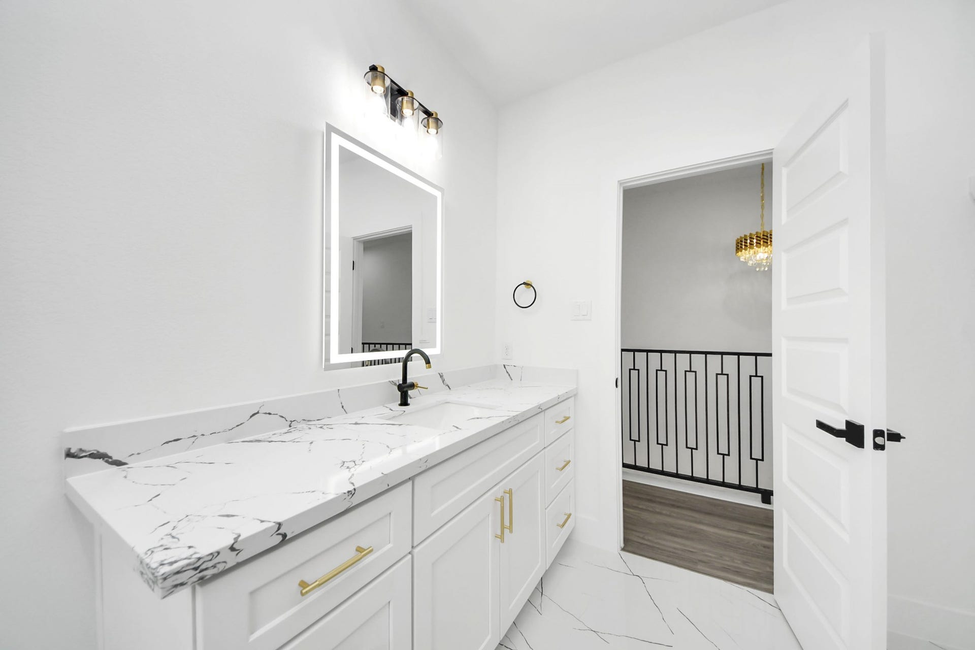 6711 Crestmont Street, Houston, TX 77033 Elegant bathroom with a sleek marble countertop, modern fixtures, and a chic lighted mirror, offering a luxurious and contemporary feel.