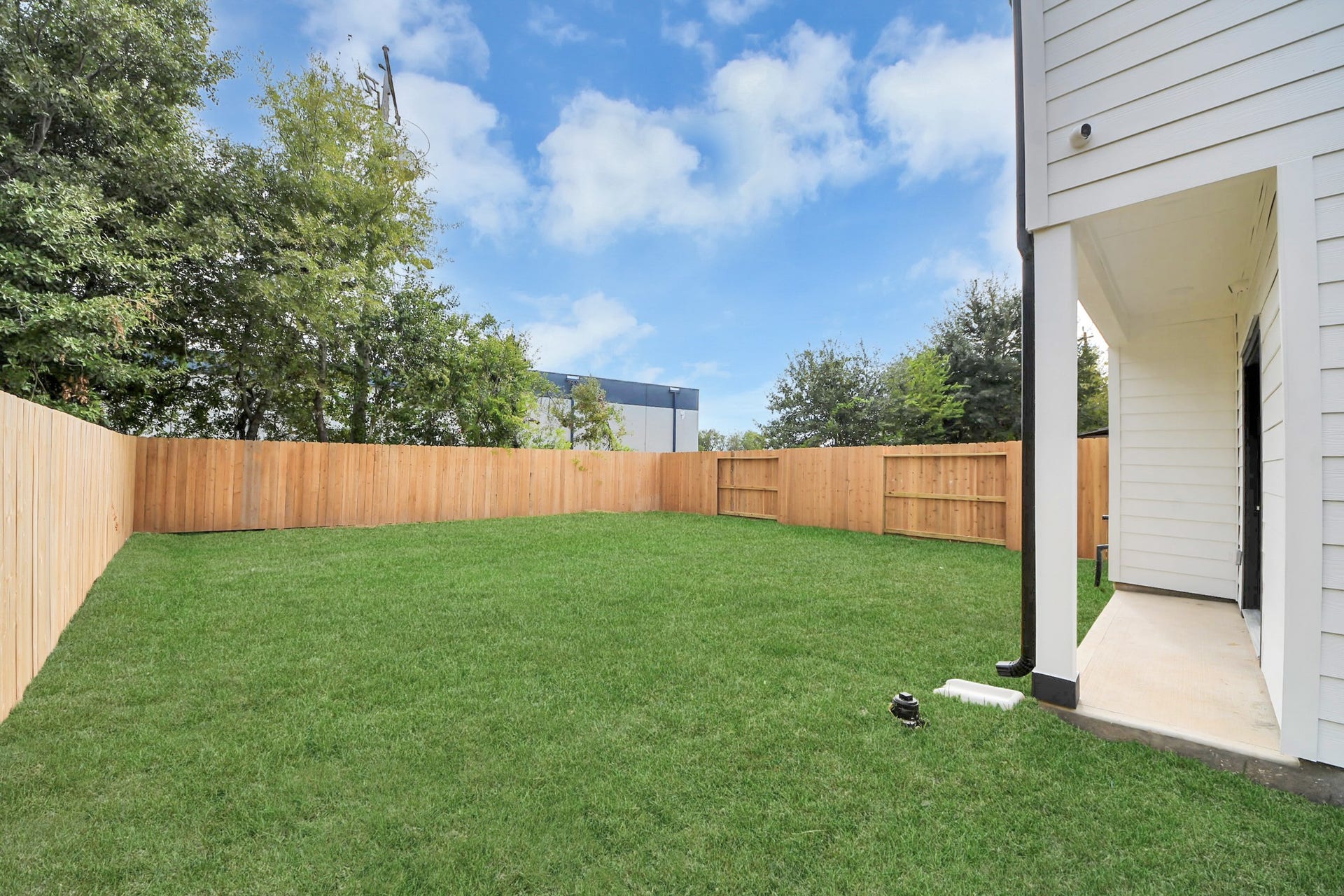 6711 Crestmont Street, Houston, TX 77033 Spacious backyard with lush green grass, bordered by a sturdy wooden fence, perfect for outdoor activities and relaxation.