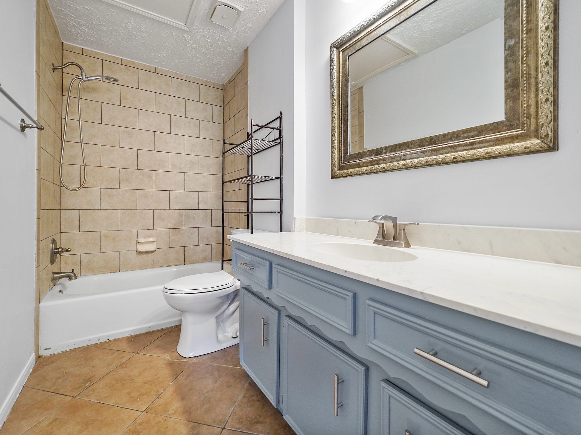 48 Chapparal Court, Missouri City, TX 77459 Bathroom with tile floors. New Toilet, Freshly painted cabinets and walls. Tile surround in the shower.