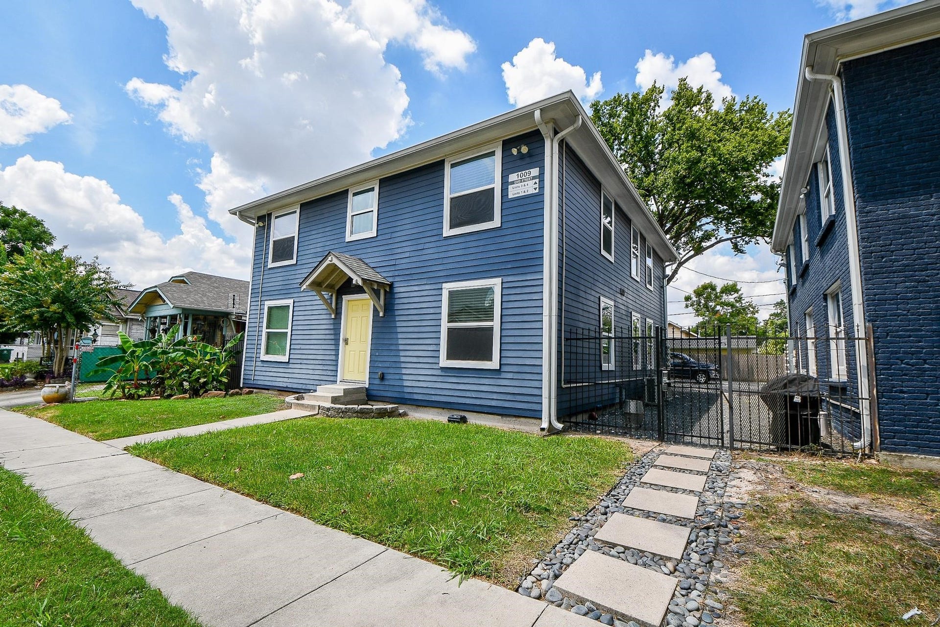 Well-maintained front yard, a side gate leading to a driveway, and a modern design perfect for family living.