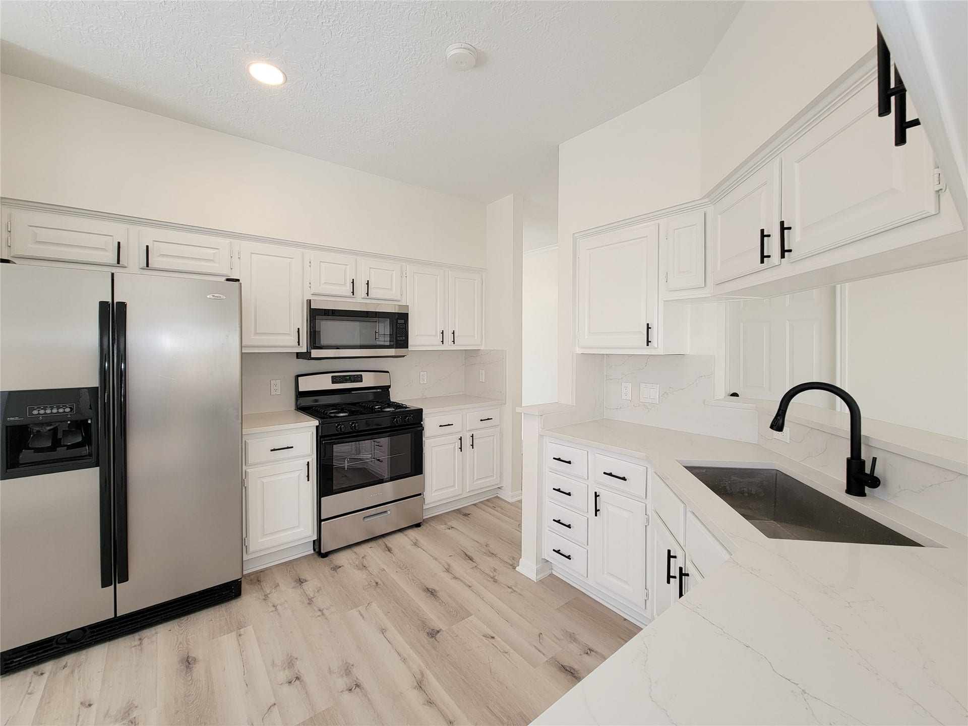 1422 Mabry Mill Road, Houston, TX 77062 the remodeled kitchen, an entertainers dream, open to living room with bar top counter and luxurious full quartz backsplask