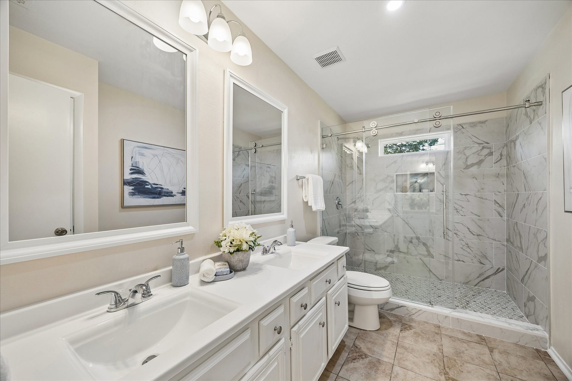 The recently renovated primary bath with double sinks and a huge walk-in shower.