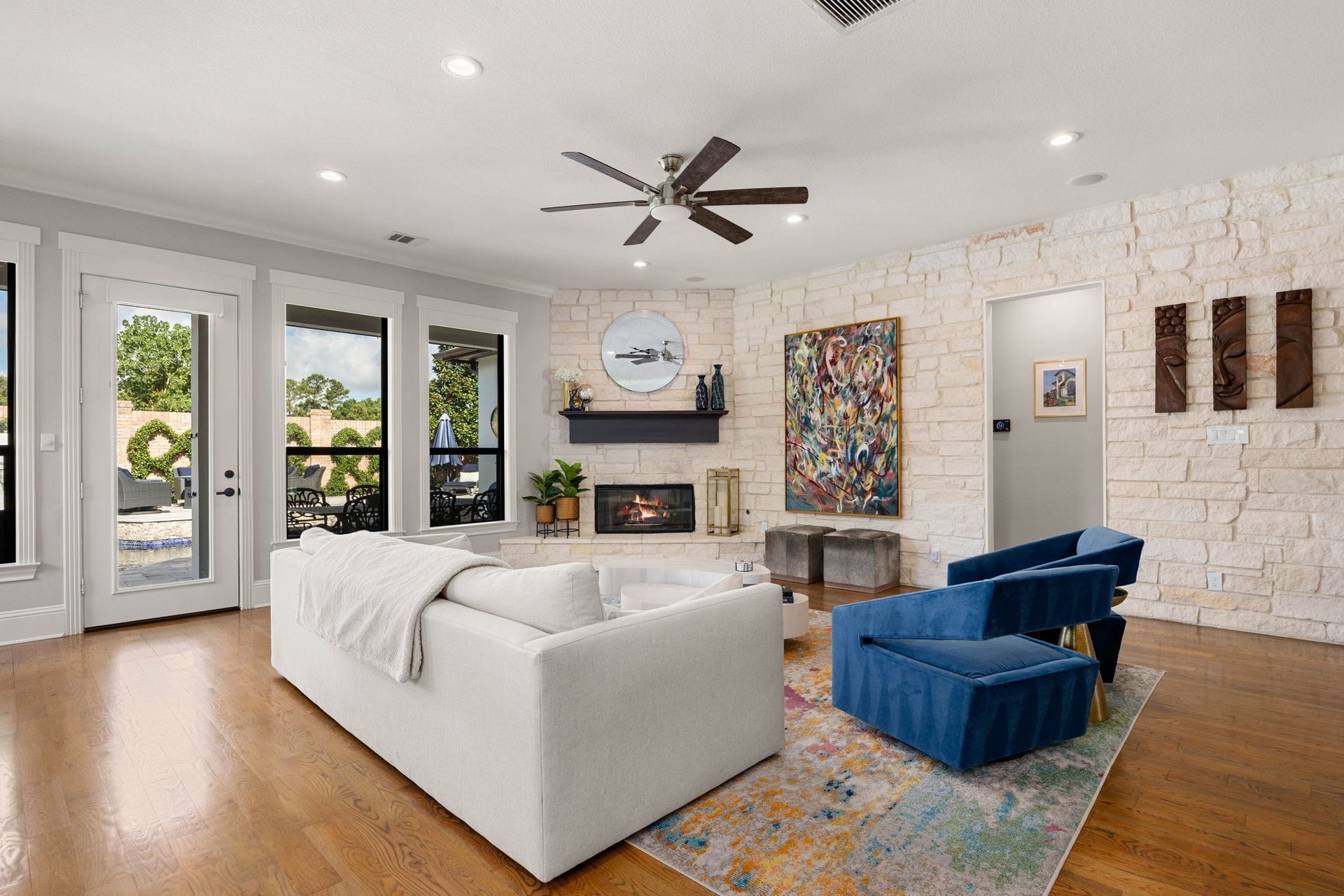 1847 Candlelight Place Drive, Houston, TX 77018 Elegant living room with abundant natural light, featuring a cozy fireplace with a stone accent wall.