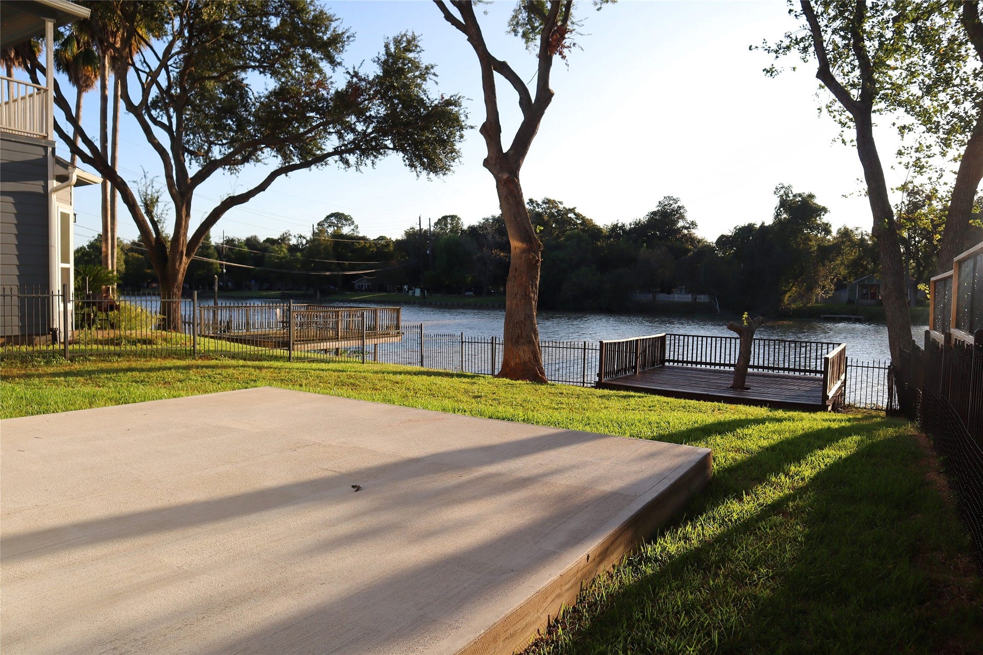 114 Oyster Creek Drive, Sugar Land, TX 77478 Enjoy serene waterfront living with this spacious backyard featuring a private deck overlooking the water, surrounded by lush greenery and mature trees.
