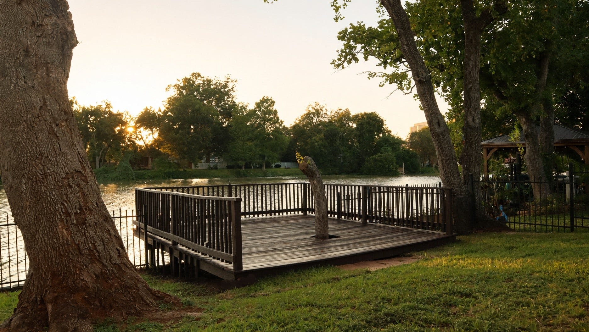 114 Oyster Creek Drive, Sugar Land, TX 77478 Charming deck for fishing, surrounded by lush trees, perfect for serene sunset views and outdoor relaxation.