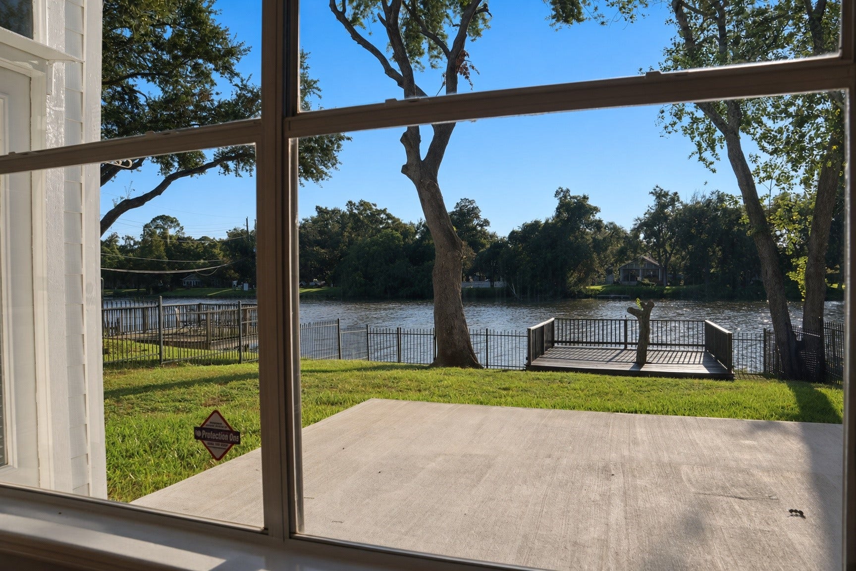 114 Oyster Creek Drive, Sugar Land, TX 77478 Enjoy serene waterfront views from your living room, featuring lush greenery and a private dock perfect for relaxation.