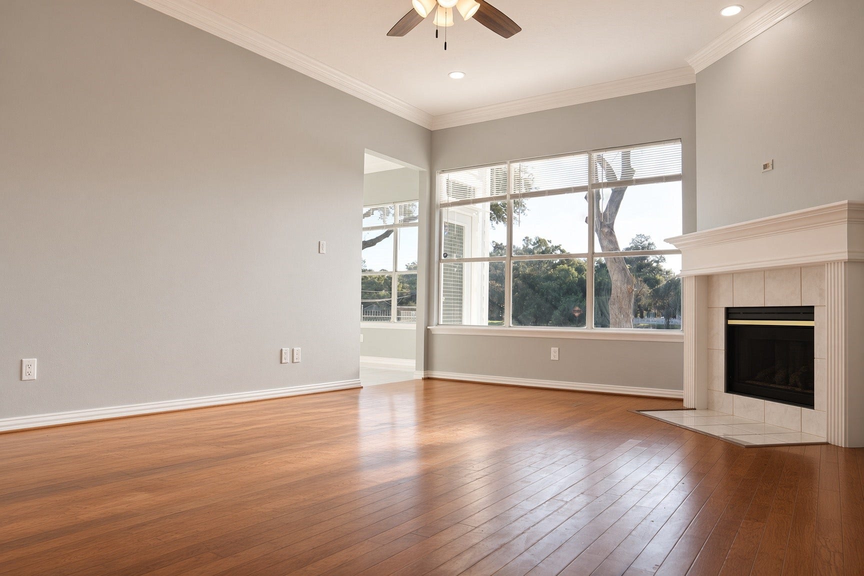 114 Oyster Creek Drive, Sugar Land, TX 77478 Bright and spacious living room featuring sleek hardwood floors, a cozy fireplace, and large windows offering serene views.