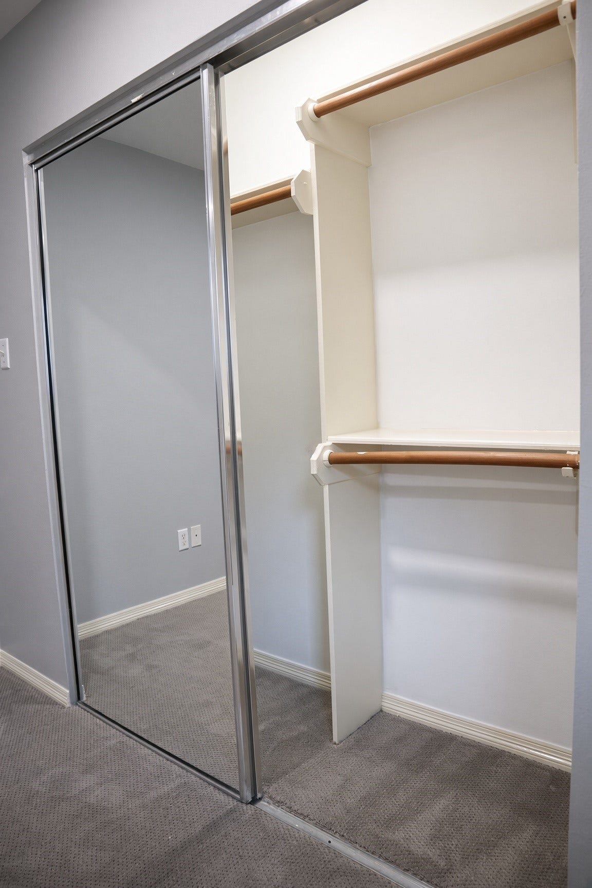 114 Oyster Creek Drive, Sugar Land, TX 77478 Spacious closet in bedroom 2 with mirrored sliding doors and ample hanging space, practical for organized storage.
