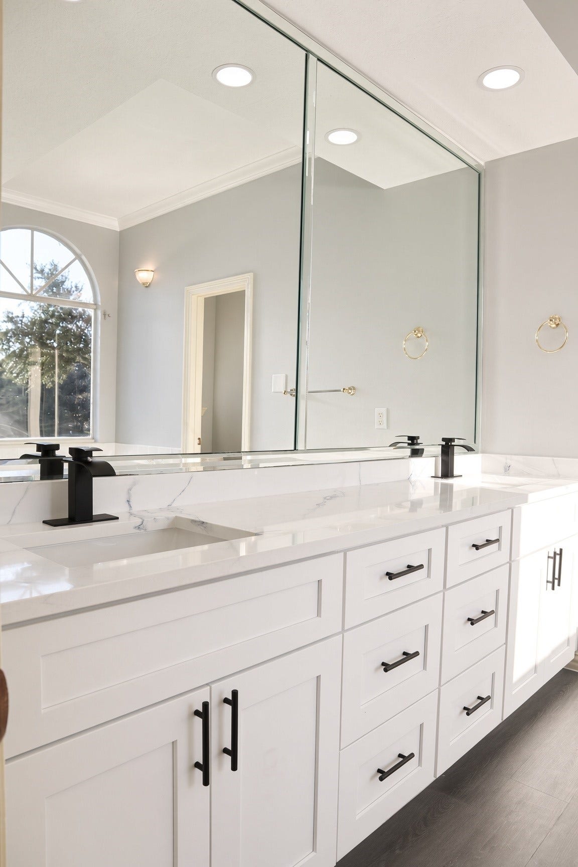 114 Oyster Creek Drive, Sugar Land, TX 77478 Elegant bathroom featuring a double vanity with sleek black fixtures, modern cabinetry, and a large mirror enhancing the spacious feel.