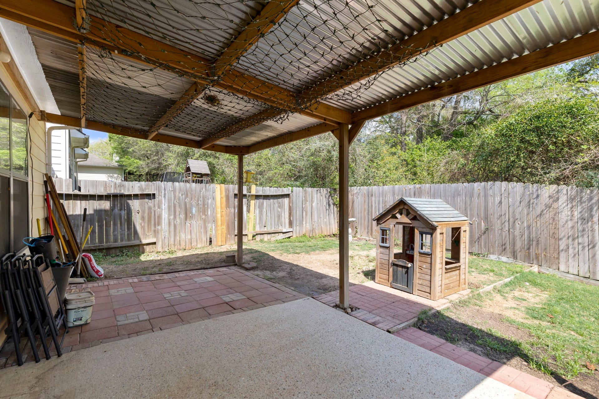 8022 N Tarrytown Crossing Drive, Conroe, TX 77304 Charming backyard features a covered patio area perfect for relaxing and a delightful playhouse for children, all within a private fenced setting.