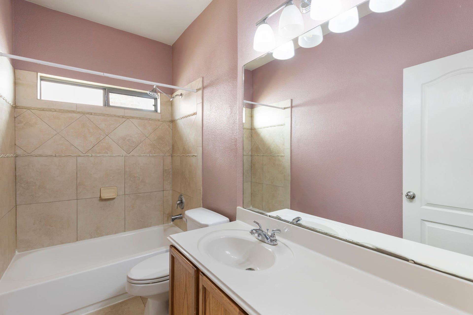 8022 N Tarrytown Crossing Drive, Conroe, TX 77304 Charming bathroom with a soothing color palette, featuring a tiled shower-tub combo, large mirror, and modern lighting for a bright and inviting space.