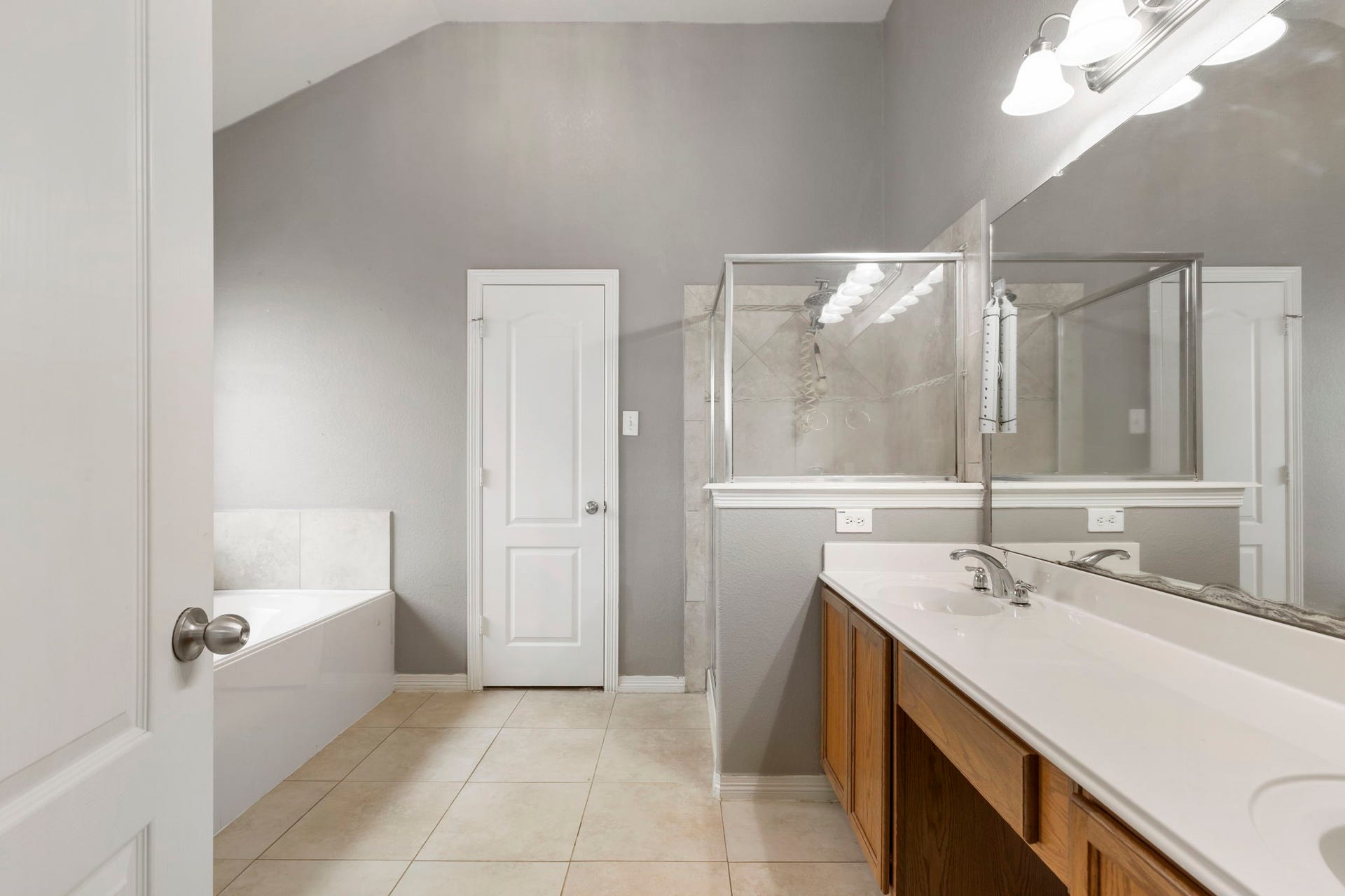 8022 N Tarrytown Crossing Drive, Conroe, TX 77304 Luxurious primary bathroom featuring a sleek double vanity, spacious walk-in shower, and a relaxing jetted tub, all enhanced by elegant finishes and abundant natural light.