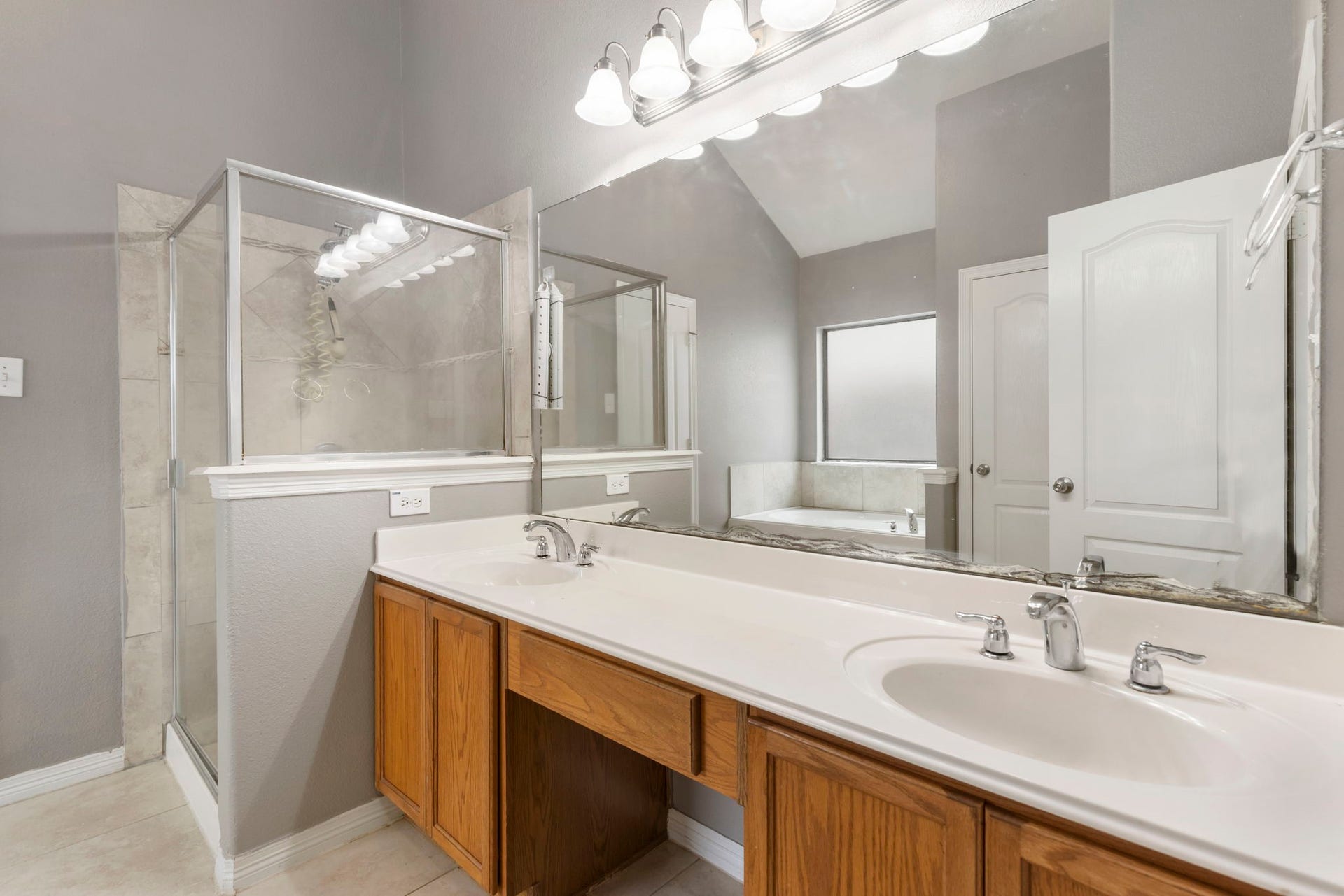 8022 N Tarrytown Crossing Drive, Conroe, TX 77304 Luxurious primary bathroom featuring a spacious double vanity, elegant glass-enclosed shower, and a relaxing jetted tub for ultimate comfort.