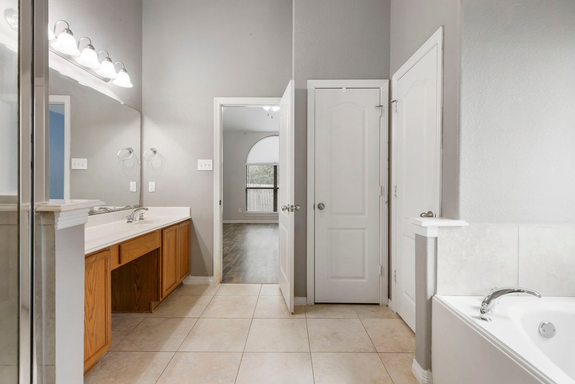 8022 N Tarrytown Crossing Drive, Conroe, TX 77304 Experience luxury in the primary bathroom with its elegant dual sinks, spacious layout, and relaxing soaking tub, offering a serene retreat.