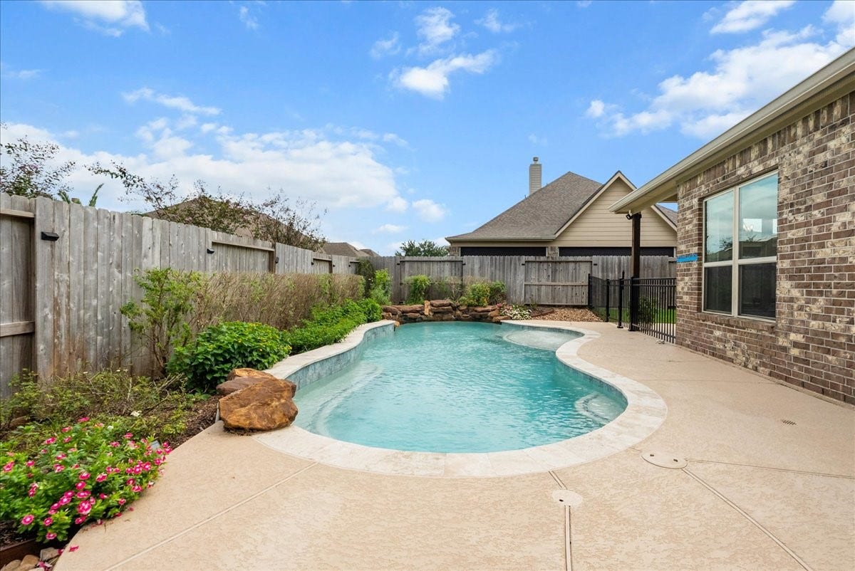 1413 Coffee Mill Court, League City, TX 77573 Step outside to your private backyard oasis featuring a sparkling pool, extended patio perfect for entertaining, and plenty of additional yard space for the kids to play.