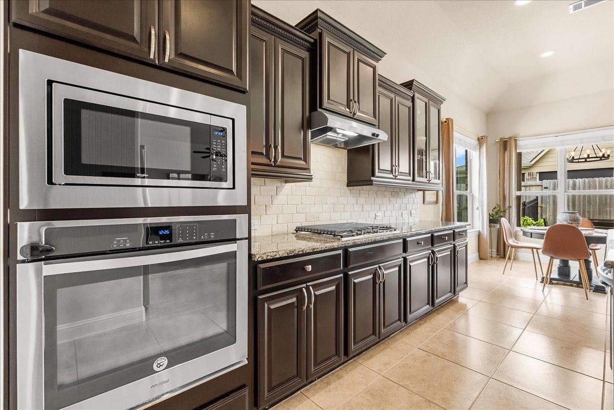 1413 Coffee Mill Court, League City, TX 77573 The chef-inspired kitchen with 42" cabinetry, crown molding, granite countertops, designer backsplash, stainless steel appliances, walk-in pantry, and butlers pantry.