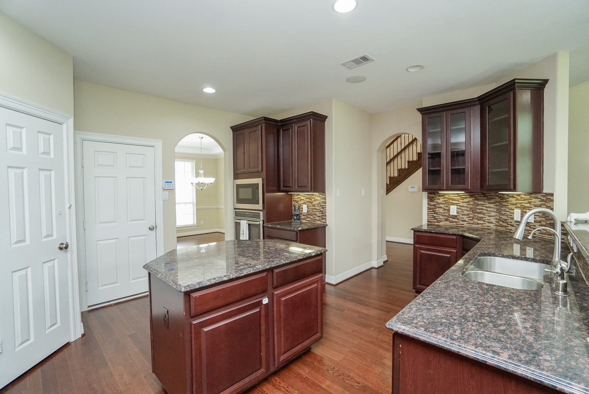 3434 Norwich Gardens Lane, Fulshear, TX 77441 The kitchen features warm colors with granite and glass tile backsplash, gas cook top, large pantry and plenty of room for your culinary treasures.
