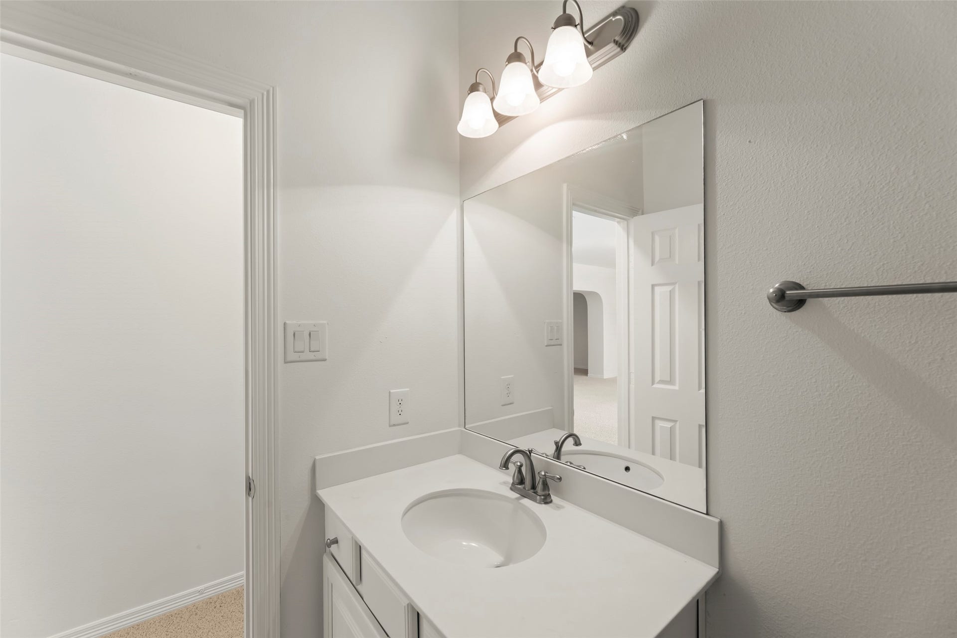 Vivid bathroom featuring a sleek vanity with a modern sink, large mirror, and elegant lighting.