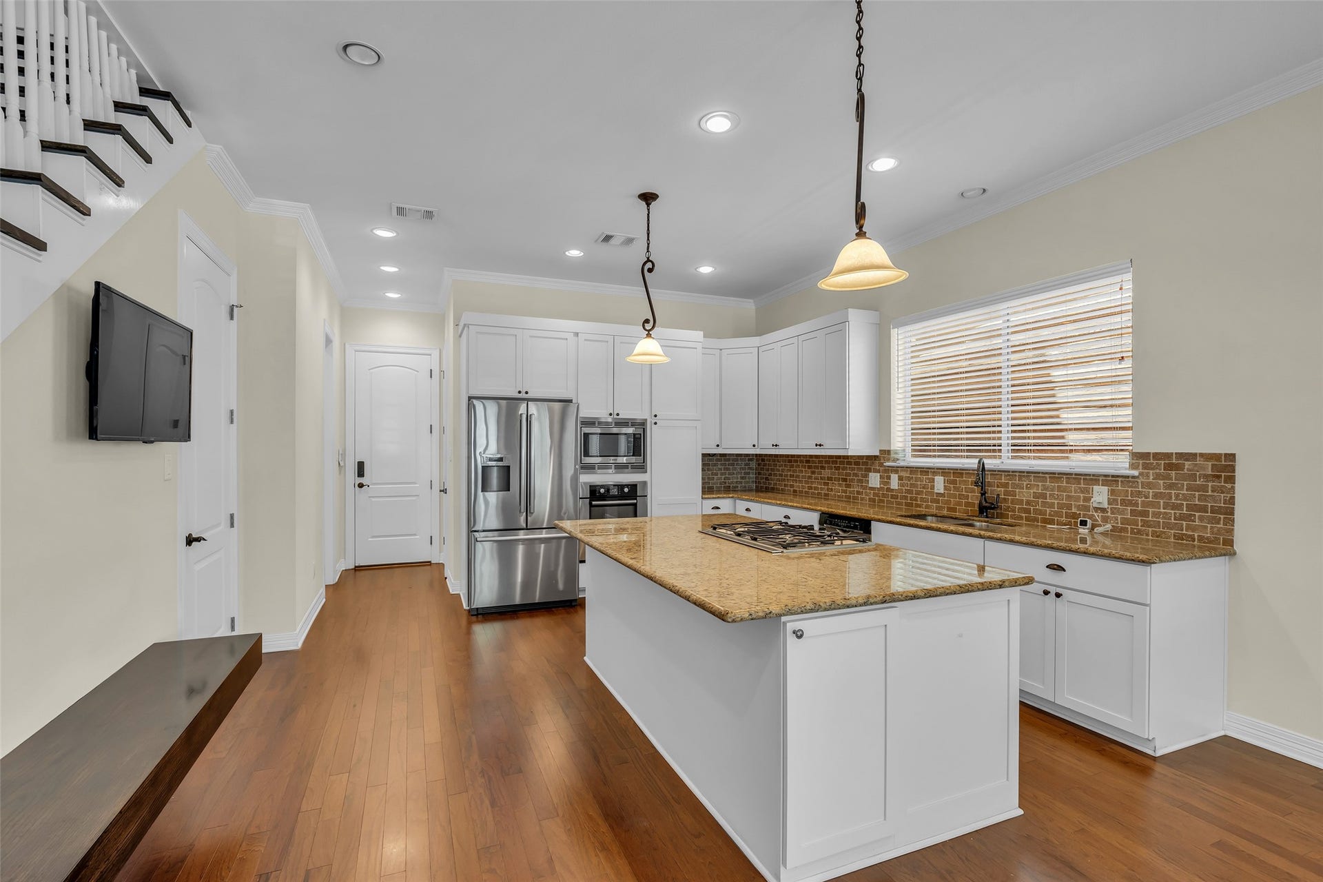 1423 Colorado Street, Houston, TX 77007 It includes a central island that serves as a cooktop, provides additional prep space, and doubles as a casual dining area for quick meals or gatherings.