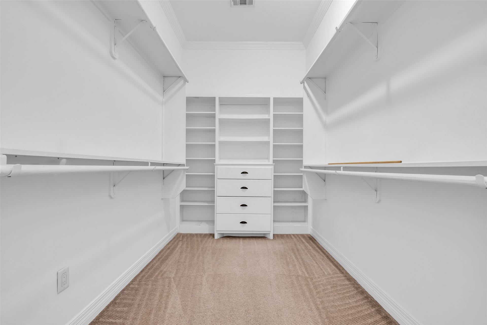 1423 Colorado Street, Houston, TX 77007 The primary bedroom includes a walk-in closet with built-in shelves and hanging racks, offering organized storage for clothing and accessories.