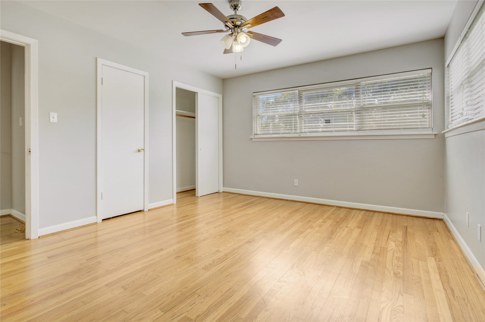 4314 Benning Drive, Houston, TX 77035 Primary bedroom, boasting, hardwood floors, lighted ceiling fan, two sets of windows, a reach in closet and a walk-in closet