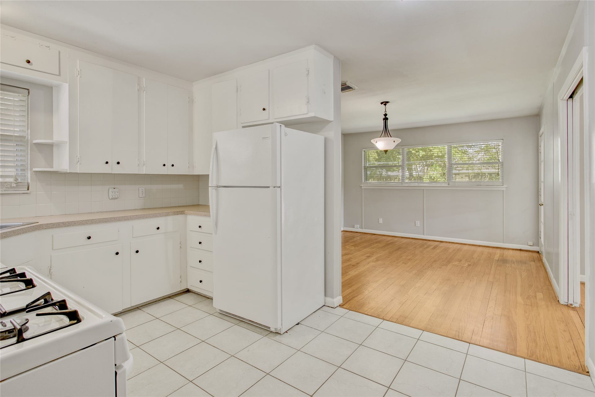 4314 Benning Drive, Houston, TX 77035 Refrigerator to remain. Freestanding gas range, tile, flooring, neutral, white paint, and access to the flex room that could be dining room, breakfast sitting, or study.