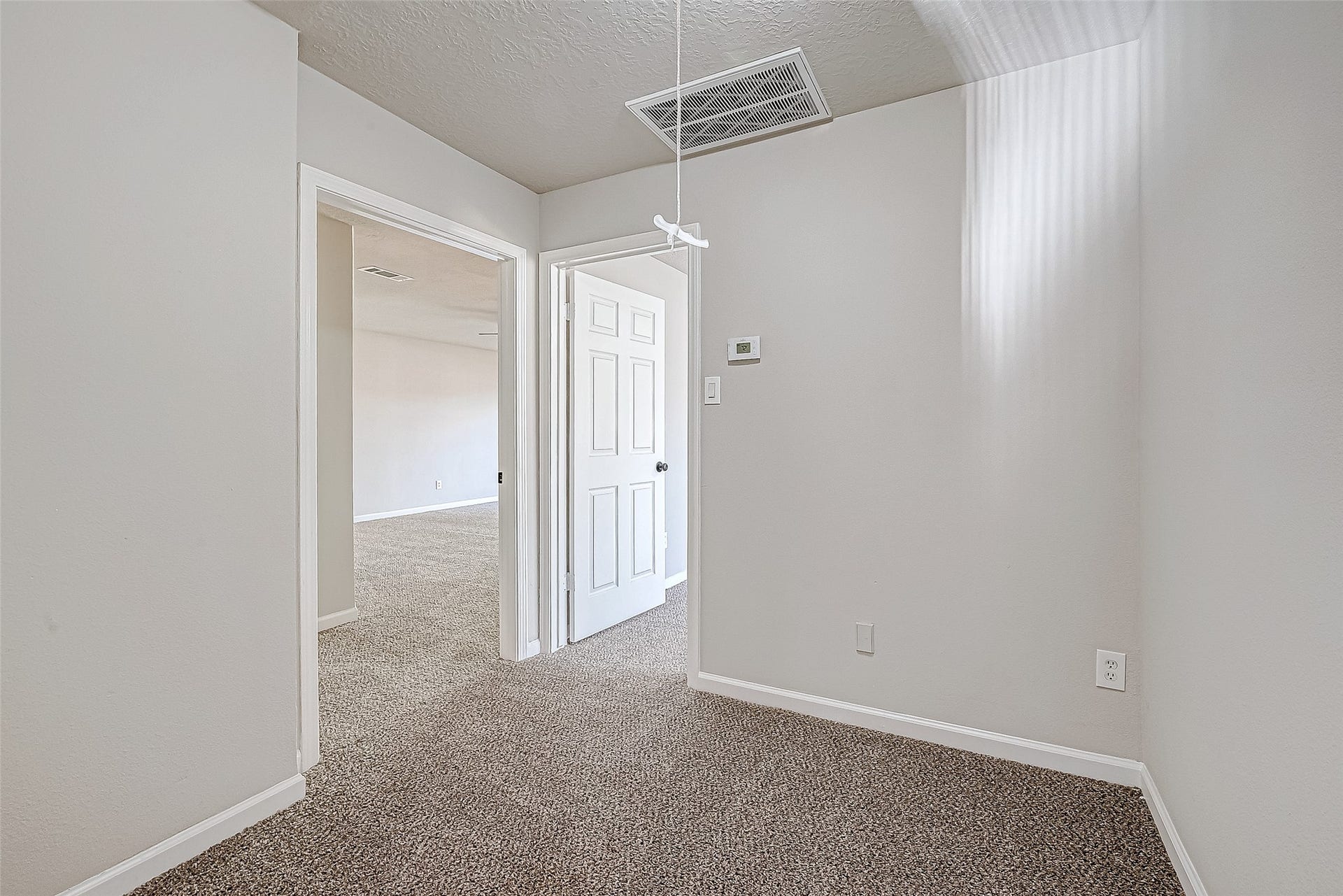 3102 Glenn Lakes Lane, Missouri City, TX 77459 A small, carpeted room with neutral walls, leading to a larger space through an open doorway.