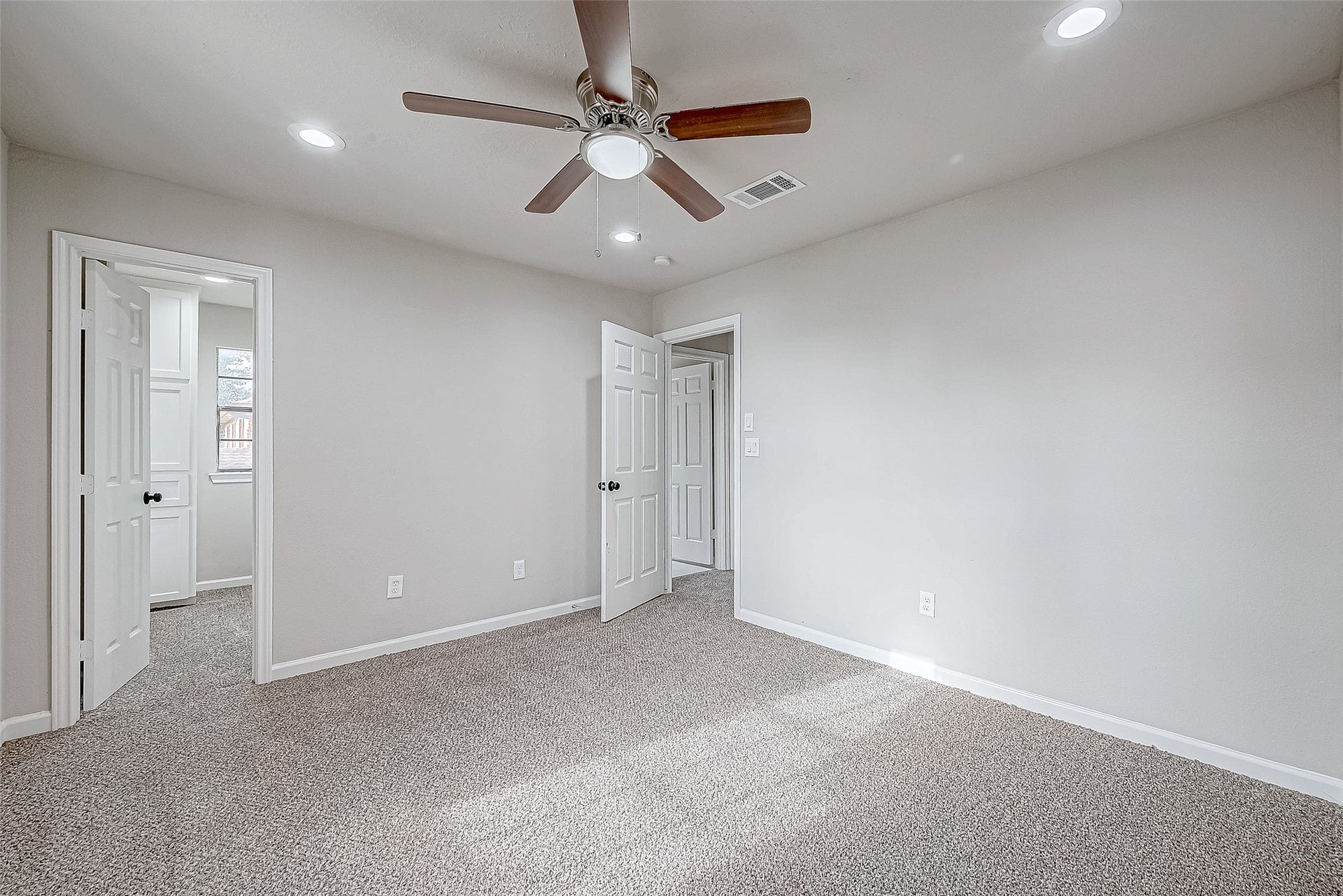 3102 Glenn Lakes Lane, Missouri City, TX 77459 Spacious and inviting bedroom featuring plush carpeting, ample natural light, and a modern ceiling fan.