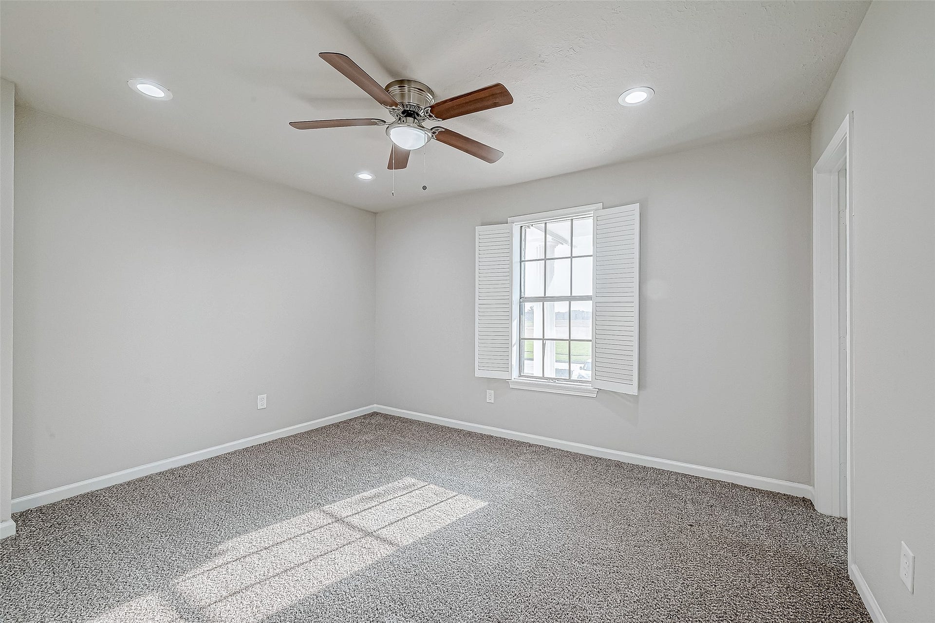 3102 Glenn Lakes Lane, Missouri City, TX 77459 Airy bedroom with crisp white walls, a ceiling fan, and a window with shutters.