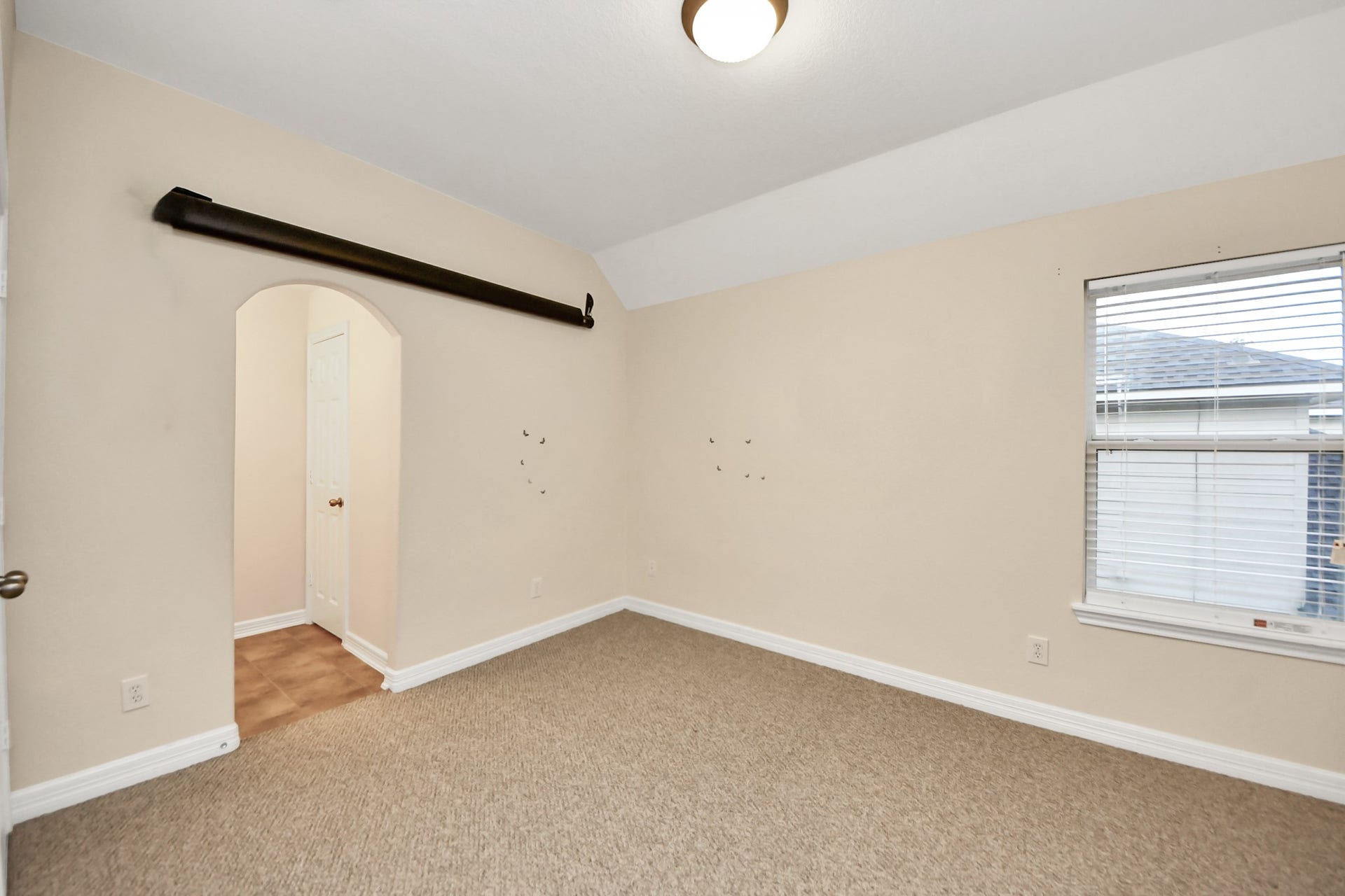 3003 Birch Landing Court, Pearland, TX 77584 A secondary bedroom with plush carpet and a gentle ceiling slope feels peaceful and bright thanks to a large window.