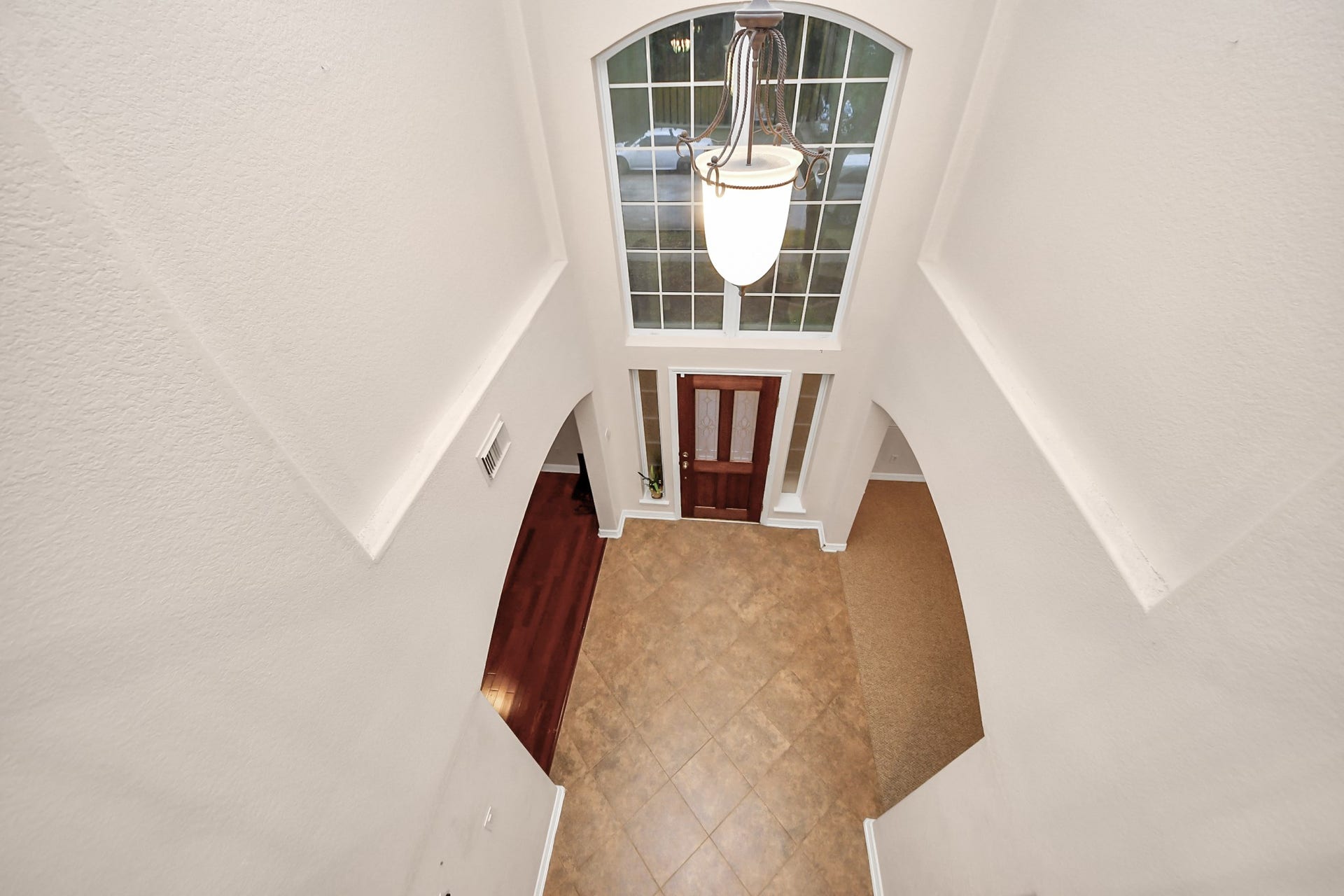 3003 Birch Landing Court, Pearland, TX 77584 From the upper floor, the foyers height and natural light take center stage, punctuated by a bright transom and pendant fixture.