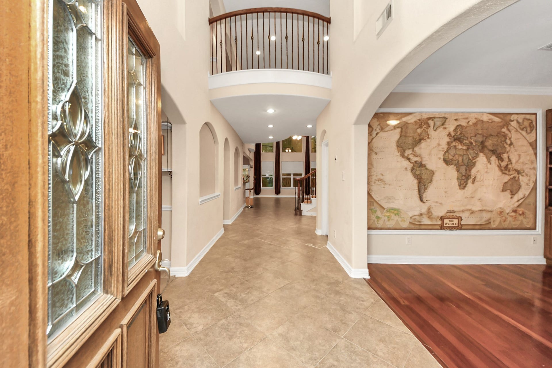 3003 Birch Landing Court, Pearland, TX 77584 The front door opens to soaring ceilings and a glimpse of the main living spaces beyond, hinting at the volume and light that define the interior.